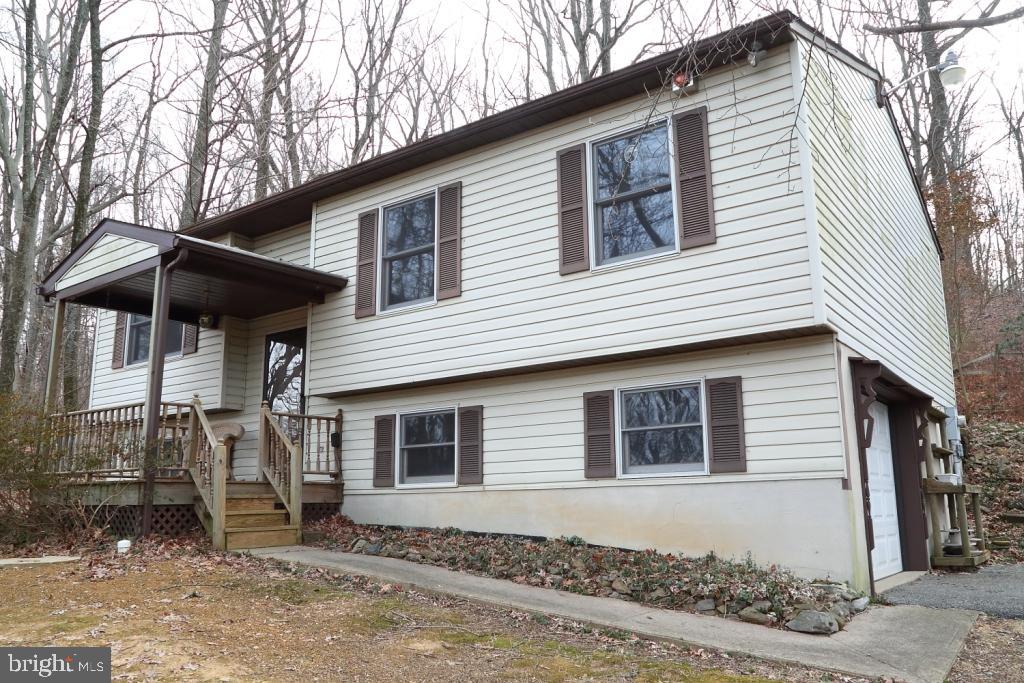 Private location situated on 1.5 acres of woodland. new flooring, C/A, patio doors, garage door and opener, 16x12 deck. Lower level plumbed for full bath. Ready to move right in.