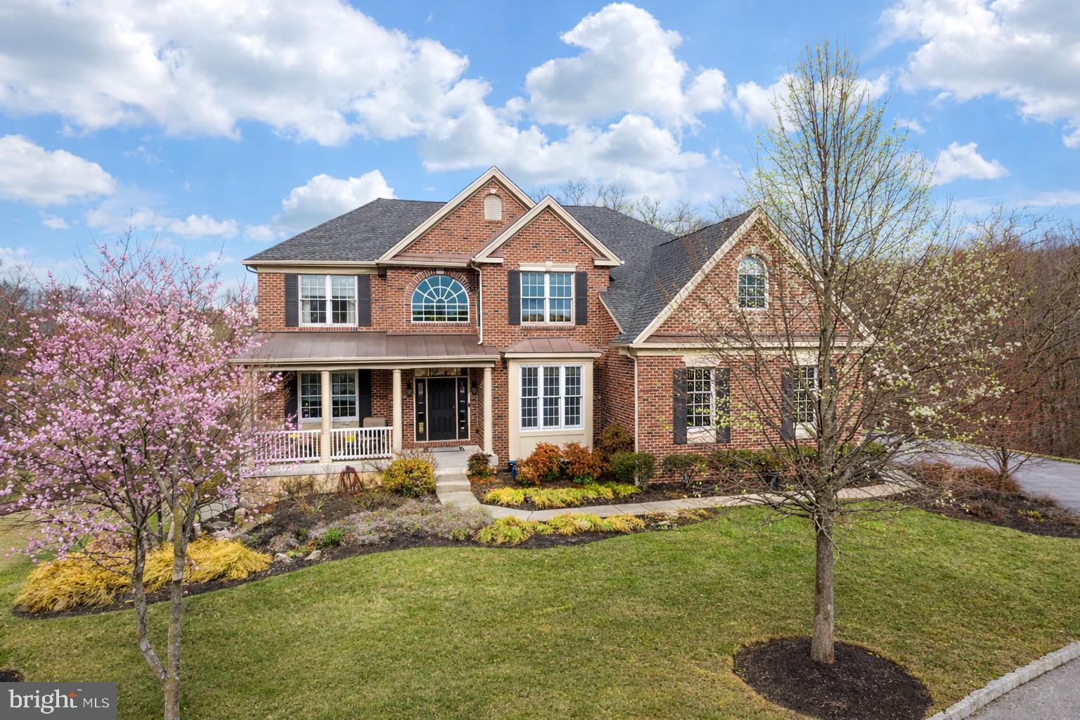 Tucked away on a quiet cul-de-sac in the sought-after Summit neighborhood of Byers Station, this rarely available 5-bedroom brick-front colonial offers exceptional natural light, beautiful wooded views, and over-the-top indoor and outdoor living spaces. A charming covered front porch welcomes you into a bright foyer with hardwood floors that flow throughout the main level. The home opens to a stunning two-story family room featuring a dramatic wall of windows and a floor-to-ceiling stone fireplace, creating a light-filled space that brings the outdoors in. The spacious eat-in kitchen is designed for gathering, with granite countertops, stainless energy-efficient appliances, gas cooking, double wall ovens, pantry storage, and a large center island with seating. The open layout flows seamlessly into the dining and family rooms, making entertaining effortless. Two sets of doors lead to an expansive rear deck that spans the entire width of the home, overlooking peaceful wooded views. A screened-in gazebo creates a private outdoor retreat—perfect for morning coffee or evening gatherings. A main level bedroom suite with walk-in closet is ideal for guests or generational living. The main level also includes a sunroom with dual fireplace, private home office, convenient laundry room and powder room.   Upstairs, a split staircase leads to a luxurious Primary Suite with its own gas fireplace, seating area, walk-in closet, and spacious bath with dual sinks and a large walk-in shower. Three additional bedrooms with generous closet space complete the upper level, including one with direct access to the hall bath. The finished walkout basement adds even more living space with a recreation area, sitting room, and included pool table. Sliding doors lead to a shaded patio featuring a 9-person hot tub, perfect for relaxing after a long day. Additional highlights include a three-car garage with interior access, skylights, ceiling fans throughout, and a recently replaced second-floor A/C unit. Residents enjoy the outstanding amenities of Byers Station, including two pools, two fitness centers, tennis and pickleball courts, basketball courts, beach volleyball, and miles of walking trails, all conveniently located near shopping, dining, parks, and Marsh Creek Lake. Attend an Open House or schedule a private tour today!
