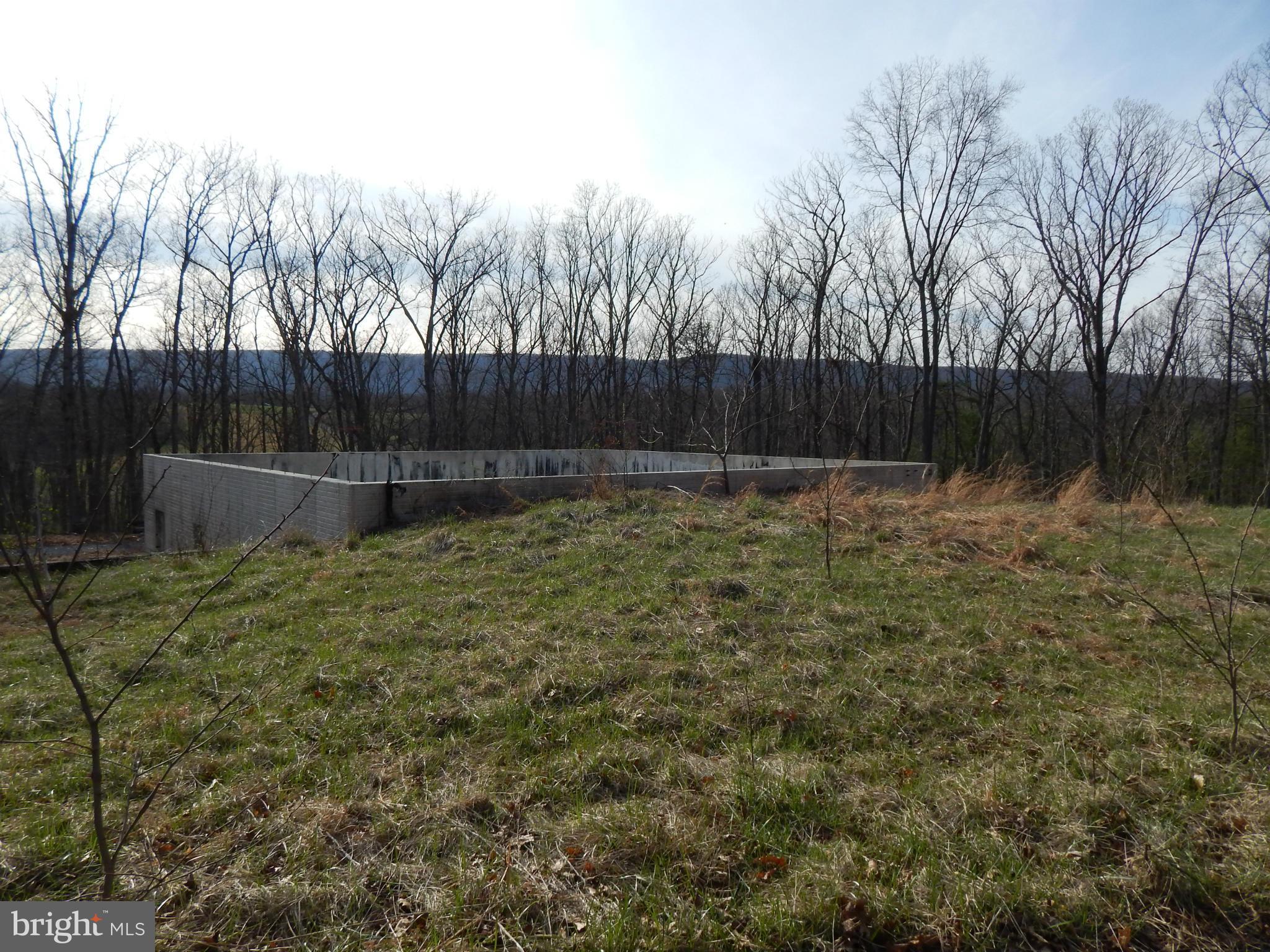 BRING YOUR HOUSE PLANS!  2.11 AC lot improved w/ a well & 6 BR septic. 45' x 50' foundation w/ poured walls & 2 geo thermal wells drilled for geo thermal heating of your home. Views of the Cacapon Mountain. Community lake w/ bath house, fishing dock & picnic area are just a few of the spectacular amenities of the unique community  Within 10 min. of Cacapon State Park & 30 min.to White Tail Skiing