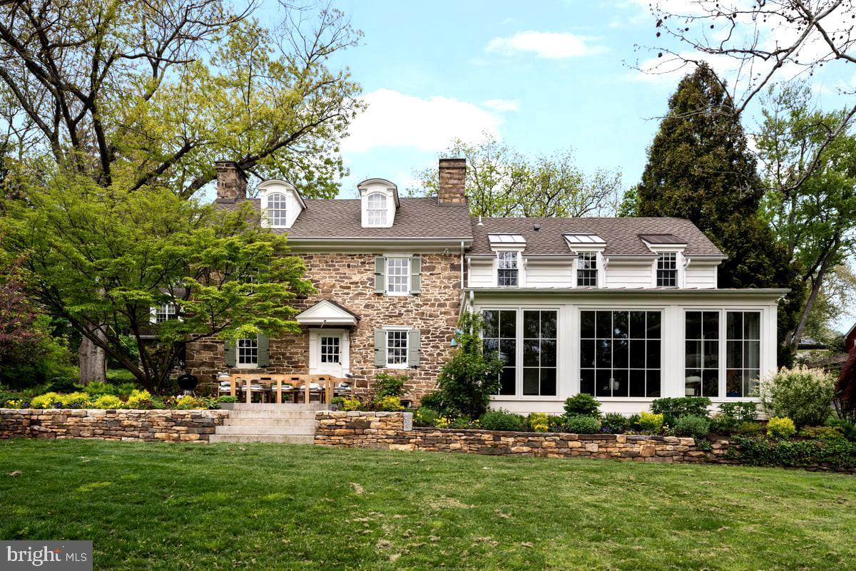 Steeped in Revolutionary-era history and set on over TWO acres, The John Fell House is one of the largest parcels in Doylestown Borough. This is a rare and remarkable property featuring a fully renovated and restored farmhouse with a permitted guest house, together totaling 7 bedrooms, 5.5 baths, and 5,500 square feet across both homes. Situated just moments from the heart of town, the property offers both walkable convenience and exceptional tranquility. 
As part of the Fell family’s 18th-century holdings, this property is deeply tied to the region’s colonial past—during the summer of 1778, General George Washington stayed in this very house and the Continental Army camped on the grounds as they advanced from Valley Forge. Today, the home seamlessly blends the original 18th-century heritage with refined modern living and creates a lasting link to American history.
The original section of the home preserves the earliest craftmanship, featuring a dramatic living room with a 9-foot walk-in fireplace, exposed beams, restored stonework, and wide-plank floors. A thoughtful addition, executed by Jarret Vaughn, harmoniously blends old and new. The main level is designed for everyday living and entertaining and includes a custom chef’s kitchen, sunlit living spaces, walk-in pantry, powder room, welcoming foyer with sweeping staircase, and a sunken living room with walls of windows overlooking the spectacular gardens and grounds. 
The home underwent a comprehensive renovation by Jarret Vaughn, with architecture by Period Architecture. New roof, new electrical, new plumbing, new everything - including a high-velocity central heating and cooling system with heat pumps. Smart home automation quietly controls lighting, blinds, and irrigation throughout, delivering modern ease without compromising the home’s historic soul.
The expanded layout includes 4 bedrooms and 3.5 bathrooms, including a beautifully appointed primary suite with a spacious walk-in closet and sumptuous bath. The third-floor bedroom provides a second en-suite, with the remaining two bedrooms sharing a beautifully designed his-and-hers bathroom.
The separate guest house is fully permitted as a second residence and offers exceptional flexibility, with a full kitchen, expansive living room, 3 spacious bedrooms, and 2 full bathrooms, ideal for extended family, guests, a private office, or rental income. 
A four-car garage with two new automatic openers offers significant covered parking and storage. Above it, a large bonus space with electricity is currently used as a gym, with the bones to finish into living space.
The captivating grounds are designed by award-winning Jerry Fritz of Linden Hill and feature lush, layered gardens with multiple patios for entertaining. An exceptionally rare in-borough heated pool with all-new equipment anchors the backyard, while a 400-year-old giant sycamore stands sentinel over the front of the property. The original 18th-century springhouse has been beautifully restored with a new floor beneath its historic roof, creating a magical open-air retreat within its ancient stone walls. At the rear of the fenced grounds, a private gate provides direct access to walk into downtown Doylestown, offering effortless reach to restaurants, shops, and the train station.
The John Fell House is a once-in-a-generation opportunity: documented colonial history, an iconic stone farmhouse, fully renovated for modern living, on one of the largest private parcels in the borough.
