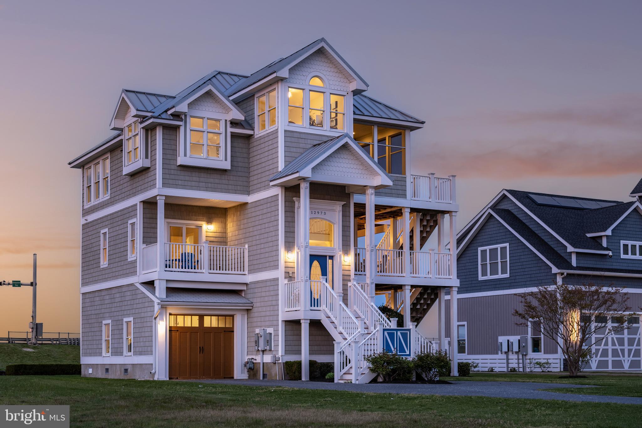 Welcome to Inlet Isle Ln a beautiful waterfront home in West Ocean City!  This home offers easy coastal living with stunning views of the Ocean City skyline. Ideally located near the beach, boardwalk, and great restaurants.  The kitchen features high-end stainless-steel appliances, quartz countertops, a tile backsplash, and a breakfast bar. It opens up to a large dining area and a spacious living room with a fireplace, making it easy to gather and relax. There’s also a wet bar and wine cooler for entertaining. Step outside to enjoy multiple decks and a screened porch perfect for catching the breeze or watching the sunrise over the water. The main level includes the primary suite and an office overlooking the water. Downstairs offers a private guest space, while upstairs features three additional bedrooms. Enjoy multiple decks, a screened porch, and relaxing water views. The deep-water boat slip with a lift makes getting out on the water simple, with quick access to the inlet and ocean.