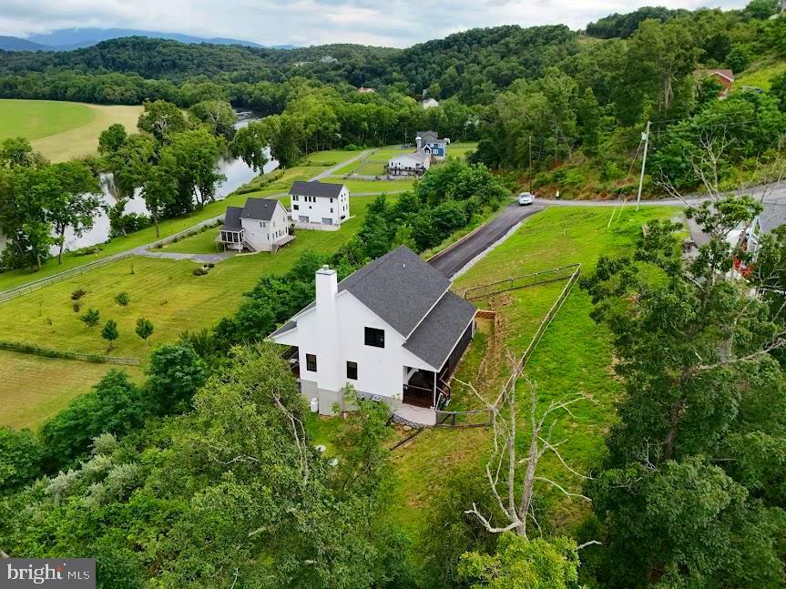 Wake up to breathtaking views of the South Fork of the Shenandoah River and the surrounding Shenandoah Valley from this beautifully maintained home in the sought-after Junewood Estates riverfront community.

Designed to bring the outdoors in, the light-filled interior features soaring vaulted ceilings, expansive windows framing incredible views, and a stunning floor-to-ceiling stone fireplace that anchors the spacious great room. The open-concept layout flows effortlessly into the beautifully appointed kitchen with marble countertops, a farmhouse sink, glass-front cabinetry, and a five-burner gas range—perfect for everyday living and entertaining.

The main-level primary suite offers a beautifully updated bath with a tiled walk-in shower and double vanity. Upstairs, the open loft overlooks the great room and provides the ideal space for a home office, reading nook, or second living area, along with two additional bedrooms and a full bath.

The unfinished lower level is already plumbed for a future bathroom, offering endless opportunities to create additional living space.

Outside, enjoy covered and screened porches, a paved driveway, and exclusive community access to the South Fork of the Shenandoah River with a dock for launching kayaks and other non-motorized watercraft, plus scenic walking trails just moments away.

Whether you're looking for a full-time residence, a peaceful mountain retreat, or an investment opportunity as a short-term rental or Airbnb, this home offers the perfect blend of comfort, quality, and unforgettable views—all while being conveniently located outside the flood zone.