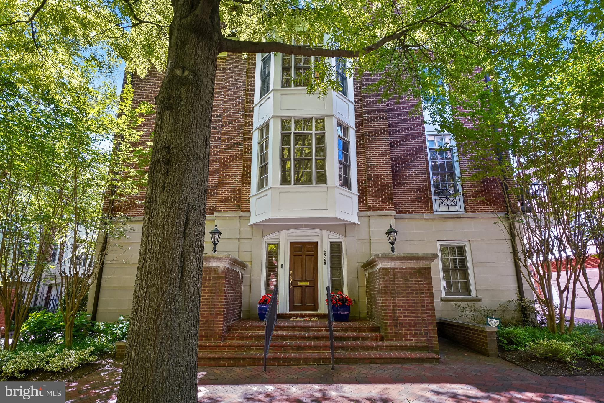 Welcome to 4828 Montgomery Lane, a stunning row home nestled on a picturesque tree-lined street in the heart of urban Bethesda. This elegant residence offers the perfect blend of luxury, convenience, and thoughtful design.  Step inside to the foyer level, where you'll find a private office with custom built-ins, a powder room, access to the attached two-car garage, and the option of taking either the stairs or your private elevator to the upper levels.  The main living level is designed for both everyday living and entertaining. The gourmet kitchen opens to a rear deck and flows seamlessly into the dining and living rooms. Windows on three sides fill the space with abundant natural light, creating a bright and inviting atmosphere throughout.  One level above, the luxurious owner's suite serves as a private retreat, featuring a spacious bedroom, sitting area with a gas fireplace and custom built-ins, dual walk-in closets, and separate spa-like bathrooms.  The top floor offers two additional bedrooms, each with its own en-suite bath, along with a conveniently located laundry area.  Ideally situated just steps from the Metro and all that downtown Bethesda has to offer, including exceptional shopping, dining, entertainment, and community events, this home delivers sophisticated urban living in one of the area's most desirable locations.