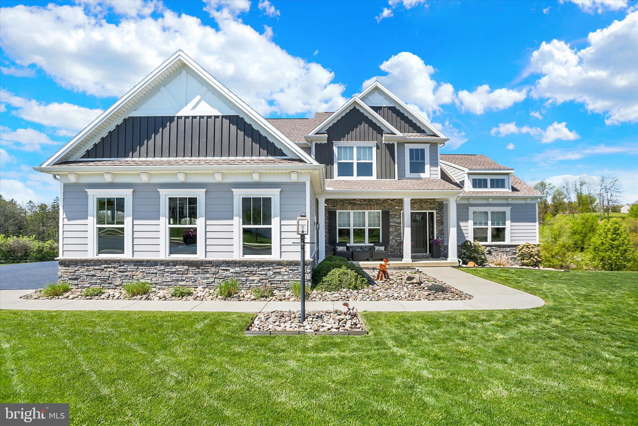 A Rare Opportunity to Own One of Amber Fields' Most Exceptional Homes

Luxury without compromise awaits at this exceptional custom-built McNaughton home, perfectly positioned on a premium homesite backing to scenic orchards and vineyards. Thoughtfully designed and extensively upgraded throughout, this expanded Martha's Vineyard model offers a rare combination of timeless craftsmanship, luxury finishes, and resort-style indoor and outdoor living—all available now without the time, uncertainty, or additional expense of building new.  

From the moment you enter the impressive two-story foyer, you'll immediately appreciate the home's open, light-filled design and thoughtfully curated finishes. The dramatic two-story great room serves as the centerpiece of the home, highlighted by soaring ceilings, an elegant open staircase, and a spectacular double-sided gas fireplace. Inside, the fireplace is accented with Hewn reclaimed wood shiplap that complements the matching ceiling beams in the kitchen, while the outdoor living area showcases floor-to-ceiling drystack stone, creating a seamless architectural statement both inside and out.

The custom-designed kitchen is equally impressive, featuring an oversized center island, designer soft-close cabinetry, granite countertops, farmhouse sink, gas cooking, corner walk-in pantry, and an inviting dining area designed for everyday living and effortless entertaining.

A true highlight of the home is the main-level owner's suite, offering both convenience and luxury. This private retreat showcases architectural ceiling and window details that fill the space with natural light while creating an elegant atmosphere. The spacious walk-in closet and beautifully appointed ensuite bath feature an oversized tiled walk-in shower, comfort-height double vanity with granite countertops, and custom-framed mirrors.

Upstairs, you'll find generously sized secondary bedrooms, each with walk-in closets, providing exceptional flexibility for family, guests, or dedicated work-from-home space.

The professionally finished walkout lower level was thoughtfully engineered to minimize structural columns, creating an expansive, open entertainment space rarely found in today's market. Anchored by a custom oversized bar complete with beverage cooler, sink, and seating for eight (included), this level offers endless possibilities for entertaining, relaxing, or hosting family and friends. A full bath completes the space, making it a true extension of the home's living area.

Outdoor living is equally exceptional. Step outside to a stunning multi-level covered composite deck featuring a cathedral ceiling, outdoor television, floor-to-ceiling stone gas fireplace, and stairs leading to an additional lower-level composite deck. Whether entertaining guests or enjoying a quiet evening overlooking the vineyards and orchards, this outdoor living space is truly one of the home's defining features. The expansive homesite offers exceptional privacy while providing ample room for a future pool within the fenced rear yard.

Additional highlights include an oversized three-car side-entry garage, a well designed laundry and mudroom featuring custom built-ins, utility sink, and drop zone with bench seating, Hardie Plank siding accented on the front elevation, a welcoming covered front porch, and an energy-efficient three-zone natural gas HVAC system.

Located within the highly desirable Amber Fields community in the Central Dauphin School District, this move-in-ready home offers the perfect blend of luxury, location, and lifestyle. All appliances convey, making this an exceptional turnkey opportunity.

If you've been considering building a luxury custom home, this is your opportunity to enjoy the craftsmanship, upgrades, and lifestyle you've been searching for—without the wait. Recently featured in PennLive's "Cool Spaces"! Schedule your private showing today and experience one of Central Pennsylvania's finest luxury homes.