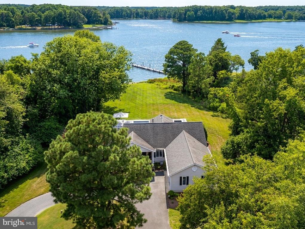 Nestled on 2.3 private acres in the sought-after Martingham neighborhood, this beautifully updated waterfront home offers one level living with the perfect blend of comfort, style, and outdoor living. Overlooking Porter Creek, the property features a private pier with lift and rip-rapped shoreline, where you can enjoy breathtaking sunsets, and endless days enjoying the water. Inside, the open floor plan flows effortlessly from the spacious living areas, open dining area, to the fully renovated kitchen, complete with quartz countertops, custom cabinetry, and modern appliances. The expansive waterside owner’s suite has a luxurious bathroom with heated tile floors, and generous closet space. Two additional bedrooms, plus a den that could serve as a fourth bedroom and custom bathroom. Step outside to a screened porch with awning or lounge beside the tiled gunite heated saltwater pool, Pebblesheen finish and surrounded by a custom deck—perfect for entertaining or quiet relaxation. Additional highlights include a two-car garage with attic storage, a laundry room with utility sink, stacked washer/dryer, and a 4-ton Legacy heat pump for year-round comfort. This is a rare opportunity to own a meticulously maintained home in one of St. Michaels’ most desirable communities, where privacy, luxury, and a waterfront lifestyle come together beautifully. Experience life alongside one of Maryland’s finest golf courses - across the street of the award-winning Links at Perry Cabin Golf Course—a premier golf destination designed by the legendary Pete Dye.