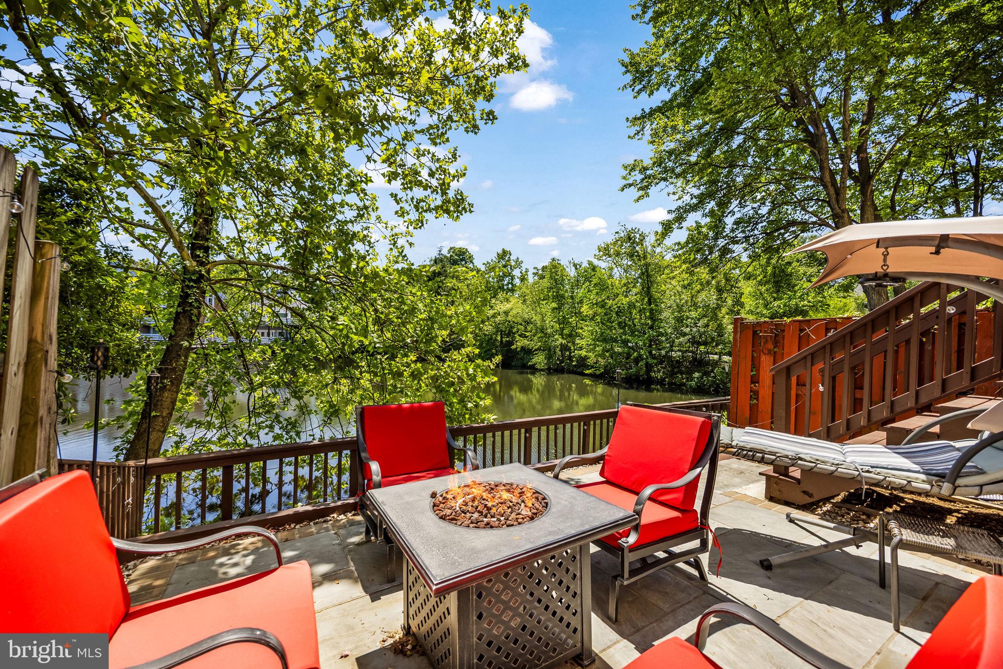 Rarely available waterfront townhome in Falls Church offering over five levels of spacious, light-filled living with beautiful lake views throughout. This beautifully maintained 3 bedroom, 3.5 bath home features soaring ceilings, new carpet throughout, and an open-concept layout designed for both comfortable everyday living and effortless entertaining. The updated, open kitchen opens to the dining area overlooking the dramatic living room with cathedral ceilings and expansive windows framing the water views and features white shaker cabinetry, quartz countertops, stainless steel appliances, pantry storage, and access to a private upper-level deck.  Doors lead to a spacious deck perfect for morning coffee or evening gatherings overlooking the lake with steps that descend to the flagstone patio below, an ideal setting for outdoor dining and relaxing by the water.
Upstairs, the spacious primary suite offers cathedral ceilings, skylights, a custom closet, and a beautifully renovated ensuite bath with dual vanities and a walk-in shower. A second upper-level bedroom features dual closets, and its own ensuite bath. The lower level includes a private third bedroom guest suite with full bath, while an additional loft area with built-in desk space provides the perfect work-from-home setup. Located in a gated community with clubhouse and pool, this exceptional home offers a peaceful waterfront retreat just minutes to Tysons, Mosaic District, I-495, Inova Fairfax Hospital, shopping, dining, and major commuter routes.