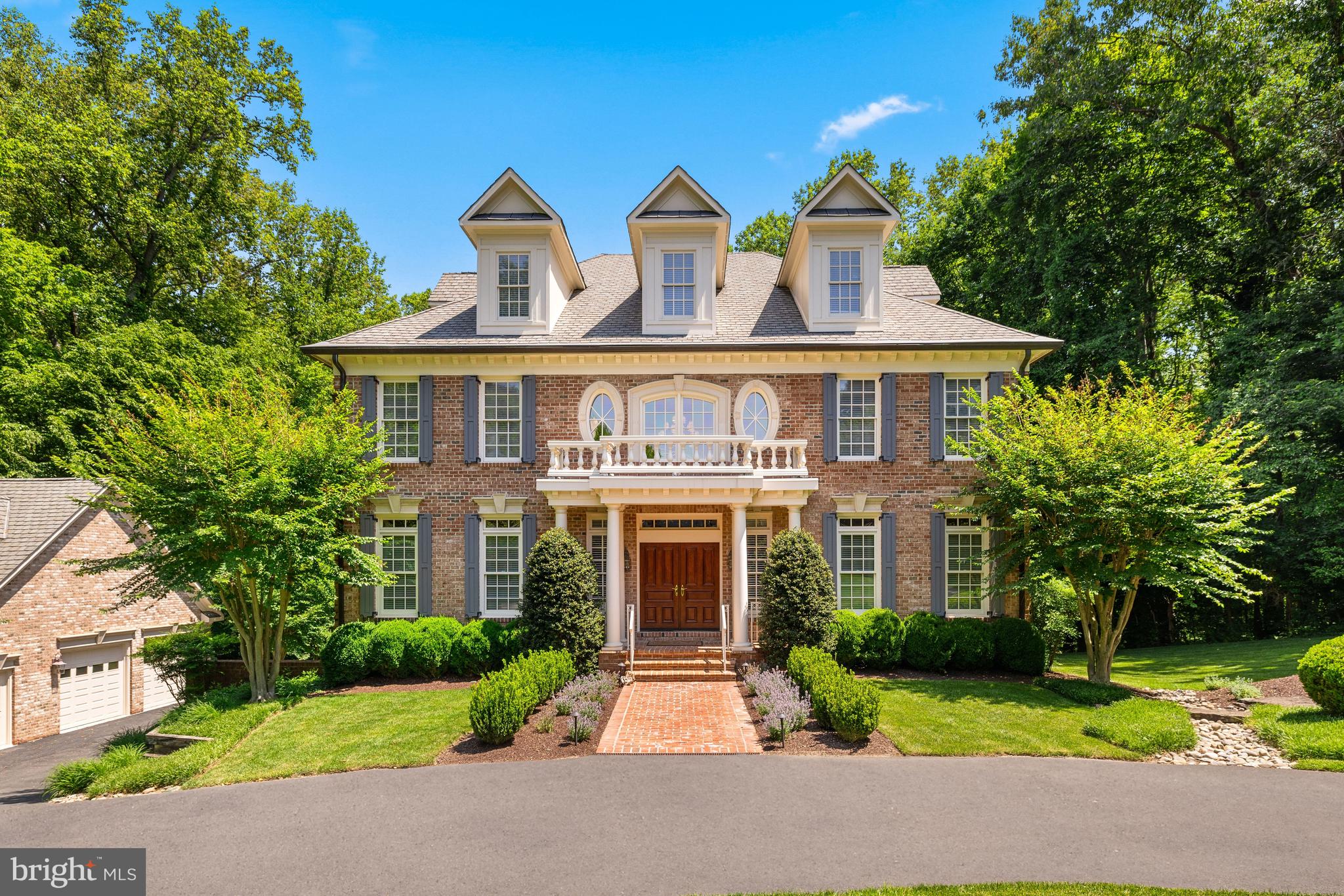 With a private and treed setting adjacent to Great Falls Park, this stately colonial residence offers four beautifully-finished levels with an elevator, five garage spaces and a back-up generator on nearly two acres in McLean. The well-proportioned and flowing layout offers ten-foot ceilings, light-filled spaces and thoughtful details throughout this home. 

The two-story foyer is flanked by both the living room and dining room with a grand bifurcated staircase. From the dining room, a butler’s pantry leads to the gourmet kitchen with a large center island, top-tier appliances, a walk-in pantry and a breakfast room. This opens to the family room with a gas fireplace and French doors leading to the large deck overlooking the backyard and rolling lawn with a propane line for grilling and stairs down to the yard and lower patio. Off of the living room, there is a powder room and a study with built-in bookshelves and a hidden entrance to an office space with a built-in desk. 

The second level offers a spacious primary suite complete with a sitting room with a beverage refrigerator and breakfast bar area, a walk-in closet and a primary bath with dual sinks, a steam shower, a jetted tub and a private water closet. There is an additional bedroom suite, two more bedrooms that share a Jack-and-Jill bath and a laundry closet on this level. Upstairs, the expansive third floor loft provides a large flex space, a full bath and a loggia overlooking the backyard. This versatile space would make an ideal office, exercise room, playroom or bedroom. 

The lower level features a media room/movie theater, a recreation room with a gas fireplace, wet bar, billiards area and French doors leading to the backyard patio. A fifth bedroom, full bath, second laundry room with a washer, dryer and sink, and access to the attached three-car garage complete this level.  

Across the driveway from the attached three-car garage, there is a climate-controlled detached two-car garage. In addition to the two car bays on the main level, there is a built-in work bench area, with the upper level featuring finished storage/flex space and the lower level offering a full workshop space. 

Featuring a fantastic McLean location, the house is a quick drive to both Downtown McLean and Great Falls village with easy access to Tysons and DC.