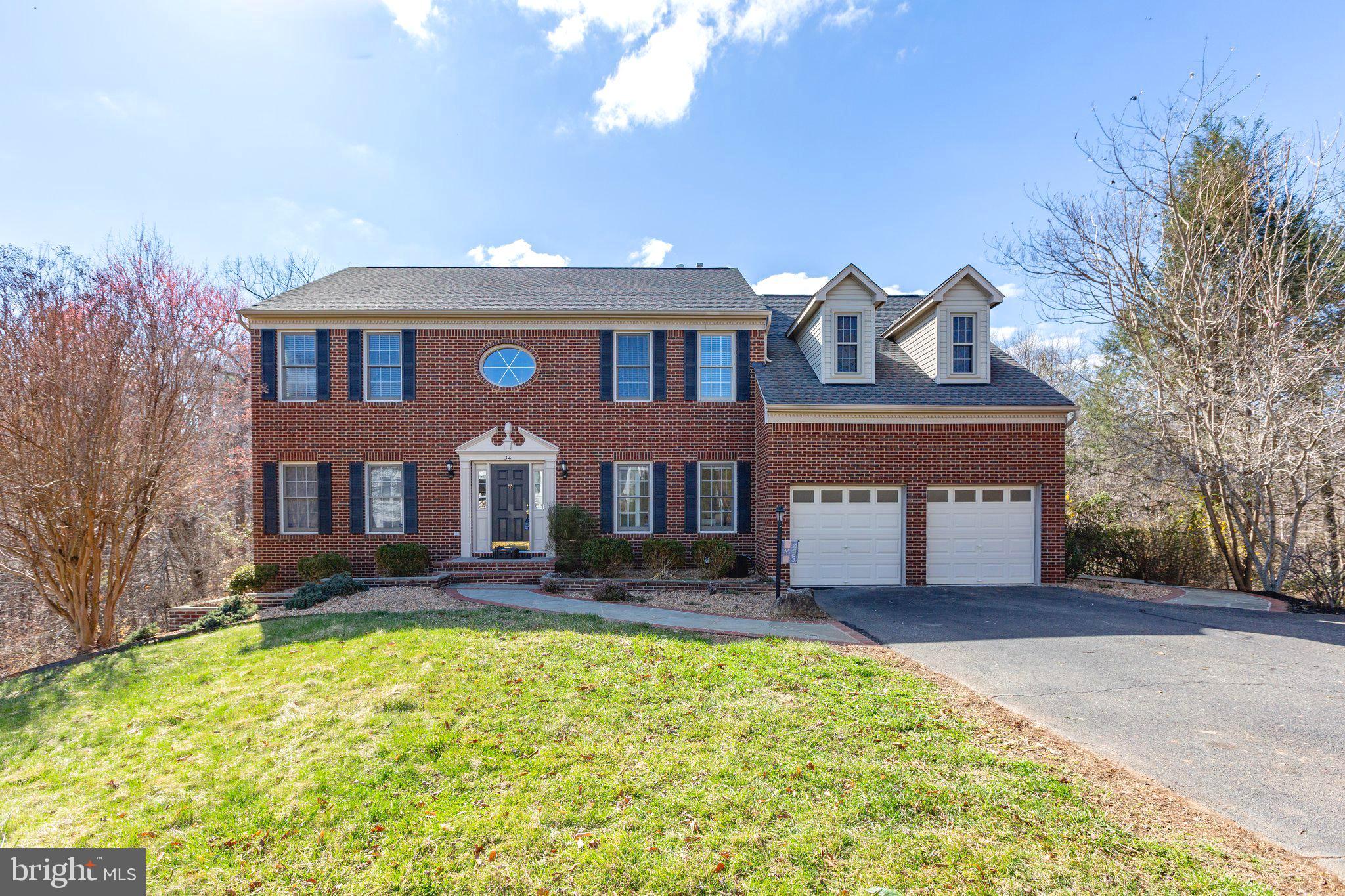 *Assumable VA Loan  2.25% INTEREST RATE* Welcome to the stunning 34 Palace Ln. Tucked away in a quiet cul de sac through your private tree lined driveway,  this gorgeous brick Colonial home is the largest  square foot floor plan Hampton Oaks has to offer! This home has been beautifully crafted and includes over 5,500 sq ft on three expansive levels.  34 Palace Ln has five spacious bedrooms, with a massive Primary Bedroom all  designed to provide ultimate privacy and comfort, and four full bathrooms, with one,  half powder room, each tastefully appointed with updated finishes.  Perfectly situated in the highly sought-after Hampton Oaks neighborhood, this home is the Biggest floor plan   this property combines comfort, elegance, and convenience! Step inside to find an open and inviting floor plan, with an abundance of windows throughout and generous living spaces designed for both relaxation and entertaining. As you enter the main level of this grand home, gleaming hardwood floors meet you in the airy, oversized foyer.  Its  large kitchen features modern stainless-steel appliances, ample cabinetry, exotic granite, and a magnificent island perfect for meal preparation or casual dining. One of the true gems of this home is the sunroom, offering a peaceful space to unwind and enjoy the outdoors all year round. The enclosed deck is ideal for entertaining or simply relaxing while overlooking the lovely, landscaped yard. Whether you’re hosting gatherings or seeking a tranquil spot to read or enjoy your morning coffee or tea, these spaces add extra appeal to this already remarkable home! Offering additional living space in the fully finished basement allows it to be customized to your needs. The dedicated theater room creates the perfect setting for movie nights or watching your favorite shows in ultimate comfort  with a convenient wet bar just a few feet away. There is an option for an additional fifth bedroom(NTC) and a gorgeous, custom full bath also conventionally located in this fully finished, walk-out basement.  At its exterior, the well-maintained brick adds to the home’s appeal, while the lush surrounding landscaping enhances its curb appeal. The outdoor space is also enhanced with multiple decks, and stunning  walkways, adding both beauty and functionality. Whether you're enjoying the amenity filled neighborhood or taking advantage of  nearby dining and shopping, this property exudes a wonderful balance of tranquility and accessibility. Recent years of updates/upgrades  to include, Upper Level HVAC System (2025), Island Pendant Lighting (2025), Stainless Steel Refrigerator (2025), Fresh Paint Throughout (2025), Dishwasher (2024), Water Heater (2024), Main Level and Basement HVAC System (2023), Trex Deck and Railings (2022) and Roof (2017). With a beautiful brick exterior, prime location, and thoughtful design throughout, this property is a must-see! Easy access to I-95, Commuting Lots, Quantico, and the Stafford Hospital you won’t want to miss out on this exceptional home. Schedule your private tour today!