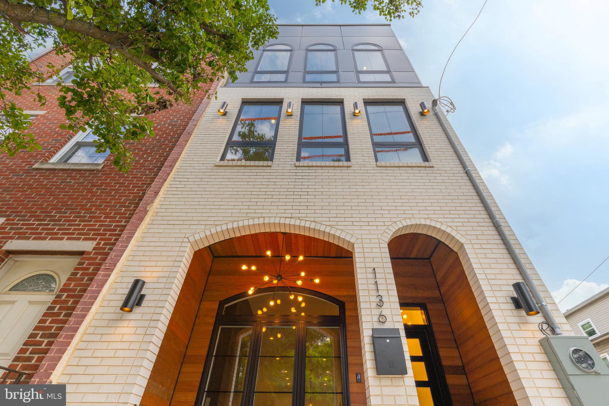 1136 Carpenter St is a completely custom 3-story home offering 4 bedrooms, 4.5 bathrooms, and an expansive roof deck with stunning skyline views. At the front of the home is one of its most unique features – a covered porch lined with shiplap on the ceiling and walls. Inside the home, hardwood floors stretch across the open main level where large windows at the front and rear fill the space with natural light. A gas fireplace with a floor-to-ceiling surround anchors the living room, while the dining area provides plenty of room for a table for 8+. The white monochrome chef’s kitchen is adorned with top-of-the-line Bertazzoni stainless steel appliances, high-gloss cabinetry, and a massive island. Off the kitchen, there’s a powder room and access to the private back patio. The finished lower level of the home host a bonus space that’s ideal for a media room, playroom, or den. A guest bedroom suite with a full bathroom completes this level. The entire second level of the home is dedicated to the primary suite, comprised of a large bedroom with three oversized windows and a huge walk-in closet. The luxurious spa-like ensuite is fitted with a double vanity, soaking tub, and glass-enclosed rainfall shower. On the third level of the home, there’s a guest bedroom suite at the front, a laundry room at the center, and a full hall bathroom and guest bedroom at the rear. Topping off this spectacular home is a huge roof deck, with breathtaking, unobstructed views of the city skyline. 1136 Carpenter St is located on the border of two of Philly’s most vibrant neighborhoods – Hawthorne and Bella Vista. With a Walk Score of 98, this walker’s paradise is close to tons of friendly shops and restaurants. This is a truly rare opportunity to own a one-of-a-kind home.