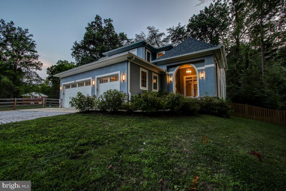 Discover a rare blend of European elegance, modern luxury, and exceptional craftsmanship in this custom-built residence completed in 2016 and situated on a beautifully landscaped quarter-acre lot with mature pine trees and a gated entry. Featuring a striking stucco façade, Italian-inspired alcove entry, and dramatic LED architectural lighting, this extraordinary home offers over three finished levels designed for both grand entertaining and comfortable everyday living. A welcoming circular driveway finished with concrete and green stone pavers leads to a highly sought-after three-car garage, a rarity in Bethesda. Inside, a dramatic two-story atrium creates a stunning first impression, while 10-foot ceilings, rich hardwood flooring, custom millwork, and premium finishes are showcased throughout the main level. The heart of the home is a gourmet Thermador chef's kitchen designed to impress, featuring professional-grade appliances, abundant cabinetry, and seamless flow into the breakfast room and expansive great room. A striking see-through gas fireplace creates warmth and ambiance between the living spaces. The adjoining butler's pantry includes a coffee bar with a built-in Wolf coffee system, making entertaining effortless. The main level also offers a private study, a bedroom with a full bath ideal for guests or multigenerational living, a spacious mudroom with additional washer/dryer hookups, and access to a large deck overlooking the beautifully landscaped grounds. The luxurious upper-level primary suite serves as a private retreat, complete with a professionally designed walk-in dressing room, private terrace, and a spa-inspired bath featuring heated floors, a heated towel rack, and premium finishes. Three additional bedrooms, two full baths, and a conveniently located second laundry room complete the upper level. Designed for entertainment and recreation, the walk-out lower level offers an expansive recreation room opening to a private patio, a home theater, exercise room, dedicated playroom, climate-controlled wine cellar, wet bar with kitchenette, and a full-sized in-law or au pair suite with a private bath. Thoughtfully designed with exceptional attention to detail and amenities rarely found at this price point, this remarkable residence combines luxury, functionality, and timeless style in one of Bethesda's most desirable locations. Conveniently located near top-rated schools, shopping, dining, parks, and major commuter routes, this is a truly exceptional opportunity to own a custom-built masterpiece.