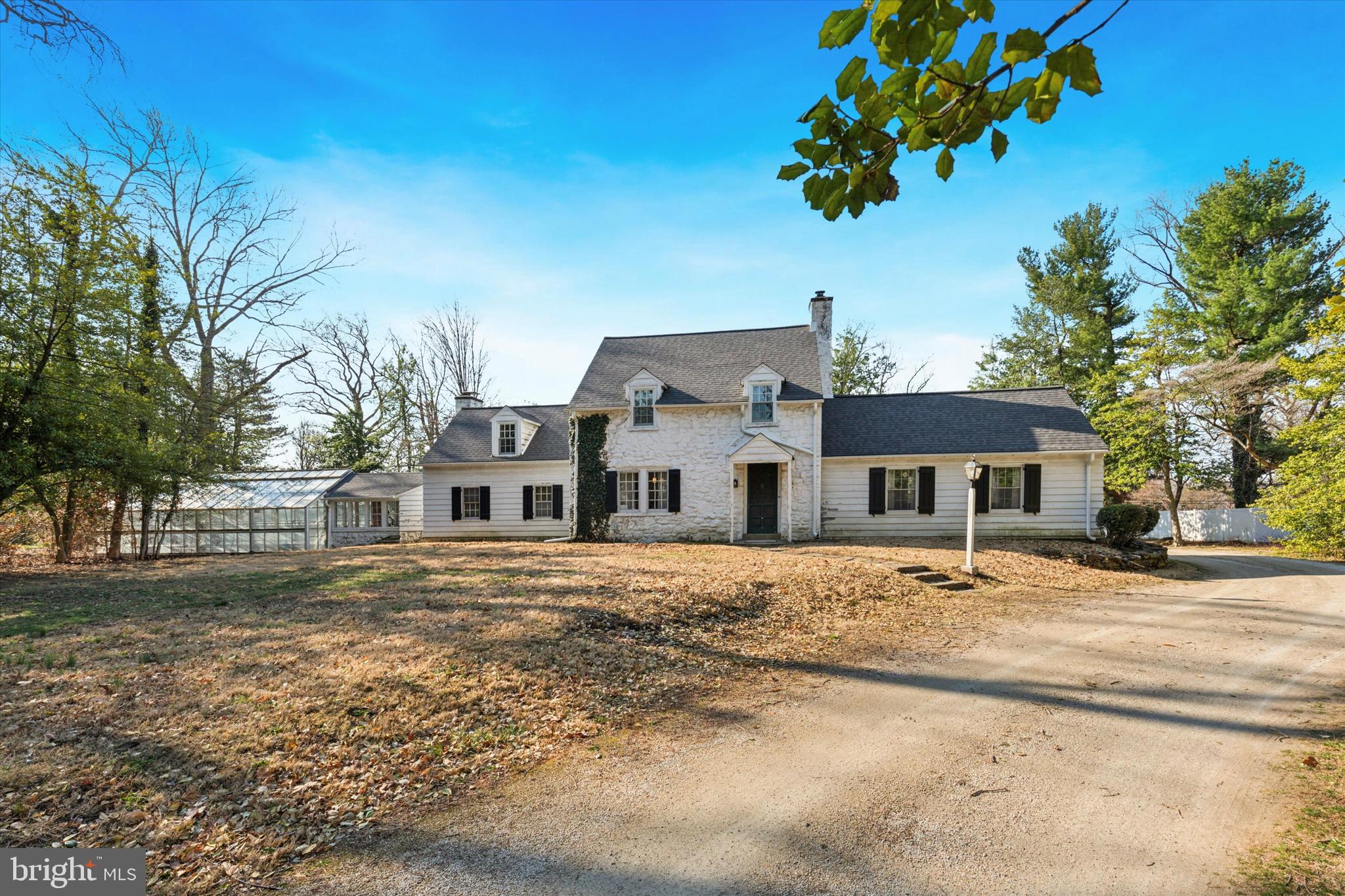 This is the one you've been waiting for!  Nestled on 1.5 acres, this Extraordinary 3-bedroom, 2.5-bath single-family home blends timeless elegance with modern comfort and a gardeners delight. Upon entry, you’re greeted by a beautiful flagstone foyer and an elegant front staircase that sets the tone for the home’s classic design. Decorative arched doorways, crown molding, chair rail, solid wood doors and sconce accents add to the refined character throughout the home. The expansive 25x19 Great Room is a true highlight, featuring vaulted ceilings with exposed wood beams, oversized decorative pendant lighting, and a striking floor to ceiling stone gas fireplace with a slate hearth. A charming split barn door and ceiling fan complement the space, while a French double-door exit leads to the rear slate patio—perfect for entertaining or relaxing. The formal dining room, accessed through a split pocket door, is bathed in natural light and boasts two built-in corner cupboards, a separate built-in cabinet, crown molding, chair rail, and beautiful pegged hardwood flooring. The room’s elegant ambiance makes it ideal for family dinners or hosting guests and is conveniently located right off the kitchen. The kitchen is designed for functionality with wood cabinetry, a stainless-steel sink and countertops, a ceramic tile windowsill, and ample cabinetry for all your storage needs, with the ceramic tile flooring adding a touch of charm. Step into the Bonus Room, once the parlor where important news was once heard on the radio, offering many possibilities for use—be it a quiet reading room, home office, breakfast, or playroom. The home features solid hardwood floors, high baseboards, and wall sconces throughout, maintaining a consistent level of quality and sophistication. A front and back staircase provide easy access to the upper level, where all the bedrooms are generously sized and equipped with ample closet space. One bedroom offers its own private powder room, once home to a small tub. The gorgeous upstairs landing provides character including two large closets and access to pull-down attic steps for added storage. The unfinished basement includes plentiful shelving, storage closets, and a crawl space under the family room. A 2-car garage ensures convenience and ample space for storage, vehicles or outdoor equipment. Off the garage, enjoy a beautiful sunroom with vaulted ceilings and a wood-burning fireplace—ideal for year-round relaxation. The sunroom leads to another powder room and a charming greenhouse, adding extra appeal to the home’s functional layout. This property also offers an inground gunite Sullivan pool, perfect for summer enjoyment. With many updates and newer features throughout, this home combines classic charm with modern amenities. Don’t miss the opportunity to own this extraordinary property.  Let's talk about location!  This home is conveniently located in Colonial school district, close to all major arteries allowing you to get to Philadelphia International Airport, Center City Philadelphia, the PA Turnpike, Northeast Extension and so many Shops and Restaurants you will not be disappointed with the ease of commuting from this home!