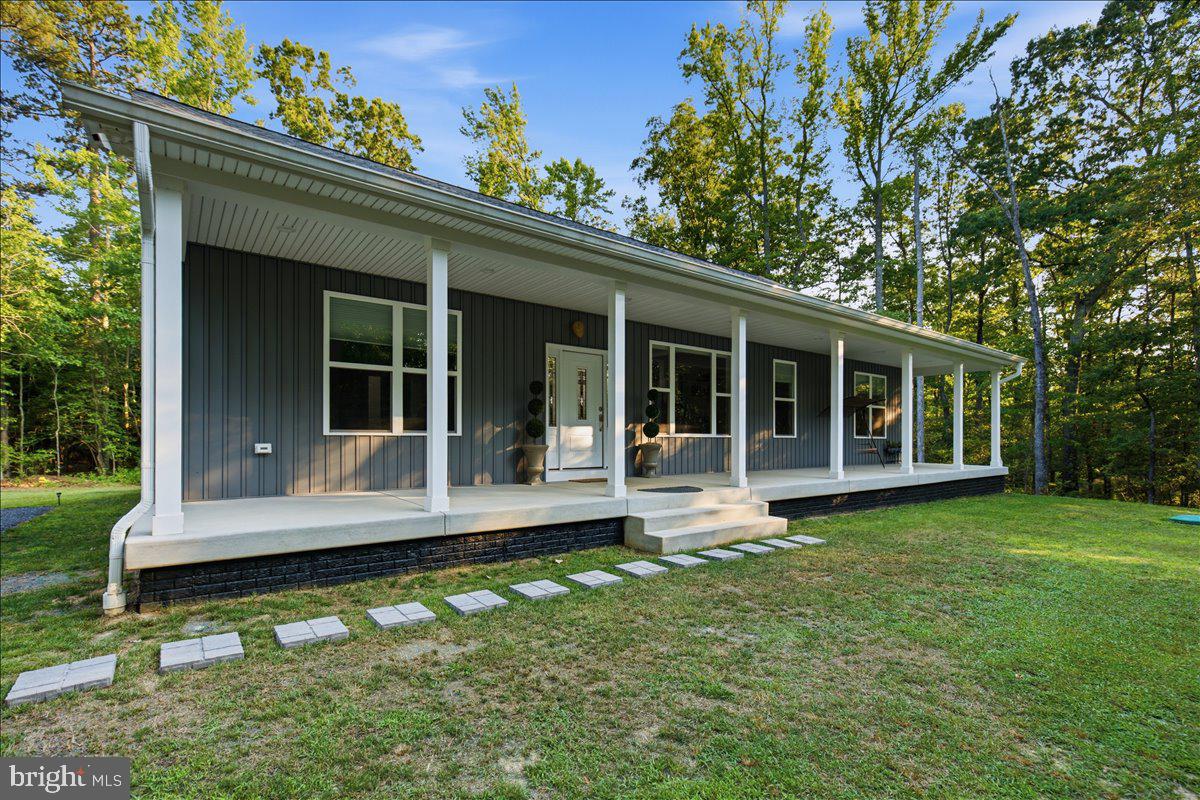 **Professional photography was delayed due to weather and will be uploaded as soon as possible** Welcome to 22405 Hood Lane - a custom home nestled on 11 acres. Built in 2024, you get all the benefits of new construction, without the wait and hassle of building. The drive along Hood Lane feels so private and serene, it is easy to forget that you are just minutes from both Downtown Leonardtown and area shopping in California!

Situated to maximize the view, the 60ft x 8ft front porch looks out onto a cleared lawn surrounded by wooded privacy. Enter into luxury – every inch of this home was thoughtfully designed, and with so many upgrades and extra features, it is truly one of a kind! Completely carpet free, lvp flooring flows through the open floorplan living, dining, kitchen, laundry, and bedrooms. Modern wide trim, recessed lighting, and upgraded light fixtures are also featured throughout, along with ADA compliant, 36” interior doors. The dining room overlooking the front porch and yard, features wooden accent wall and picture window with power closing shade. In the living room, a stone fireplace with Harman Accentra pellet stove insert provides ample heat in the winter and a focal point year-round. French doors lead to the back porch with vaulted ceiling, tv outlet, and ceiling fan.

The breathtaking kitchen is the crown jewel of this beautiful home, with custom maple cabinetry, sweeping quartz countertops, and Kitchen Aid appliances with an assumable extended warranty. This kitchen features a 36” gas cooktop situated under a sleek 36” range hood and pot filler, and flanked by two built-in spice racks. The centerpiece, a massive 9.75ft x 4ft island, with cabinets and drawers on both sides, offers both storage and seating. A wet bar with glass-front upper cabinets completes the space. Off of the kitchen, is an absolutely huge combination butler’s pantry and laundry room, with utility sink and built-in pantry cabinetry with countertop. The primary suite is also generously sized and features a walk-in closet with built-in shelves. The primary bathroom has an expansive double vanity with modern medicine cabinets, and a large tiled shower with built-in bench. Two more bedrooms and a second modern, full bathroom round out this 2400 square foot rambler.

Downstairs, the unfinished basement features tall ceilings and was laid out to offer the opportunity to add two additional bedrooms, another full bath, and plenty of additional living/entertaining space if desired. In addition to this 2400 square feet, there is an additional 60ft x 8ft storage area. French doors lead to the back yard and driveway. This home also offers 350 AMP electric service with separate panel wired for a dedicated generator and the capability to add electric vehicle charging. Forestry management plan and full list of home features available.