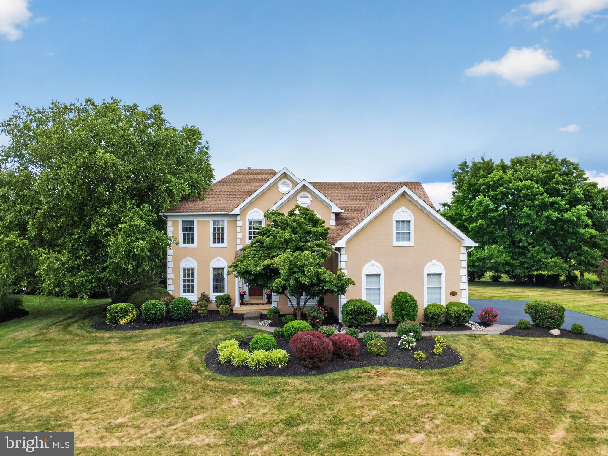 Welcome to this exceptional Toll Brothers Cornell model in the highly sought-after Yardley Estates community of Lower Makefield Township. Situated on a beautifully landscaped and private .57-acre lot, this impressive Colonial offers over three levels of thoughtfully designed living space, a three-car side-entry garage, and an outstanding combination of space, functionality, and location. A dramatic two-story foyer with an unique triple-turn elegant oak staircase and hardwood flooring creates a welcoming first impression. French doors open to a private study featuring custom built-in bookshelves and desk, crown molding, and recessed lighting, ideal for today's work-from-home lifestyle. Designed for both everyday living and entertaining, the formal living and dining rooms showcase hardwood flooring, crown molding, chair rail detailing, and decorative columns that create an open yet sophisticated flow between spaces. The spacious kitchen offers a center island, two-tone cabinetry, pantry, stainless steel appliances, wall oven, gas cooktop, recessed lighting, and hardwood flooring. The adjoining breakfast area features sliding glass doors leading to the rear patio and private backyard, while the open layout seamlessly connects to the dramatic family room with soaring cathedral ceilings, skylights, a wood-burning fireplace, and a rear staircase. Completing the main level are a well-appointed laundry room with cabinetry, utility sink, and storage closet, along with a convenient powder room. Upstairs, double doors lead to the expansive primary suite featuring crown molding, a comfortable sitting area, and an impressive customized walk-in closet with built-in organizers and center island. The spacious en-suite bath includes a soaking tub, separate walk-in shower, skylight, and dual vanities. Three additional generously sized bedrooms, each with crown molding and ample closet space, share a hall bath with double vanity. The finished lower level provides exceptional flexibility and entertainment space with a custom built-in beverage center, wine chiller and counter space, recreation area, separate sitting room, and exercise room with built-in storage, additional storage areas, and a convenient powder room. Outside, enjoy the privacy of the rear patio and mature landscaping, creating an ideal setting for relaxing or entertaining guests. This home has been meticulously maintained throughout ownership with numerous significant improvements, including a replaced roof, updated HVAC systems, kitchen enhancements, refinished hardwood flooring, replacement garage doors, exterior improvements, upgraded insulation, and the addition of a Generac whole-house generator, providing peace of mind for years to come. Yardley Estates is one of Lower Makefield Township's most desirable neighborhoods, known for its attractive homes, walkable setting, convenient access to Yardley's charming downtown, parks, shopping, dining, and major commuter routes. Residents also enjoy the benefit of the award-winning Pennsbury School District, consistently recognized among the region's premier public school systems. Conveniently located near I-295, Route 1, regional rail service, Princeton, Philadelphia, and New York City, this is an outstanding opportunity to own a well-maintained Toll Brothers home in one of Bucks County's most sought-after communities.