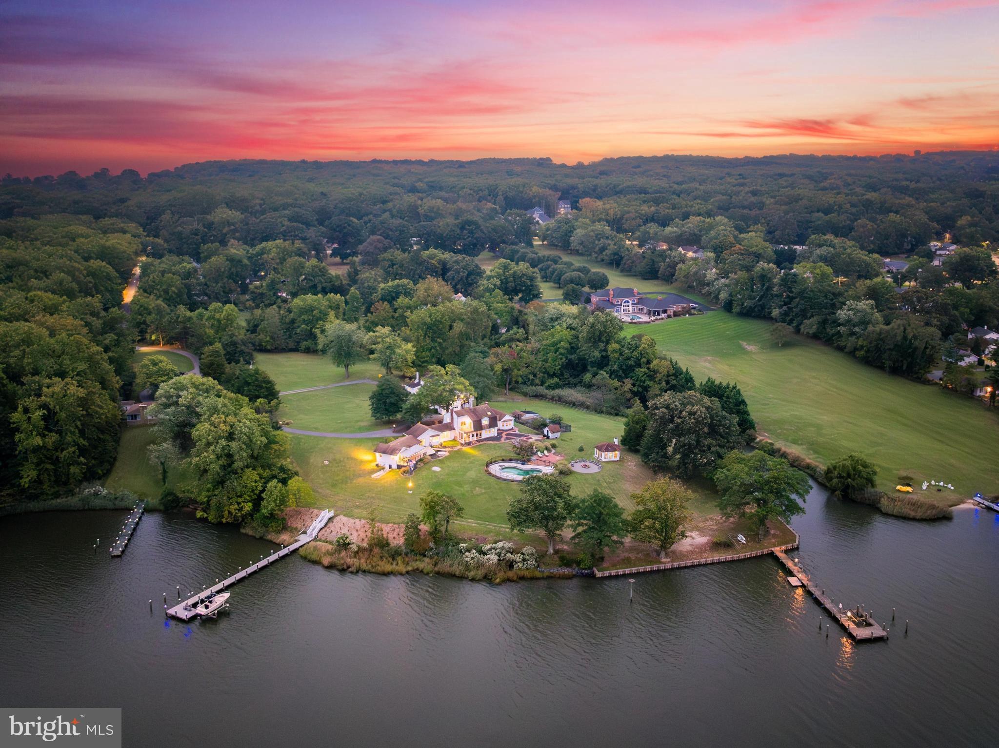 Price improvement & pool now open!! 
Discover 'Beachwood,' a breathtaking waterfront estate set on nearly 3.5 acres, offering expansive, wraparound water views. With approximately 367 feet of water frontage on a scenic point, this exceptional property is nestled along the tranquil, protected waters of Ramsay Lake—just moments from the South River and Chesapeake Bay. The beautifully landscaped grounds, featuring expansive lawns and gardens, create a serene and picturesque setting for outdoor gatherings or grand-scale entertaining.  A private deep-water dock with a boat lift is perfect for avid boaters and waterfront enthusiasts. Spend your days relaxing by the stunning waterside pool surrounded by breathtaking views. The dedicated pool house bath ensures convenience for guests and effortless entertaining. In true Maryland spirit, a charming crab house offers an authentic waterfront experience-perfect for hosting lively crab feasts with family and friends. As the evening sets in, gather around the dedicated large fire pit area, where you can enjoy the warmth of the fire and take in the peaceful ambiance. 

The main house features 4 spacious bedrooms, 3.5 baths, multiple living and family rooms, an office, an eat-in kitchen, and a screened porch perfect for relaxation. The estate also features a spacious detached garage with a private full 1 bedroom/1 bath apartment above, ideal for extended guests, an au pair, or rental potential. The 2-car garage also offers extensive storage and a workshop area. 

Once home to a neighborhood schoolhouse, the property radiates history and character at every turn. With stunning water and sunset views, this exceptional property offers boundless potential for expansion and renovation. Situated less than an hour from Washington, D.C., and just 20 minutes from downtown Annapolis, this rare waterfront gem blends exclusive, tranquil living with unmatched convenience.