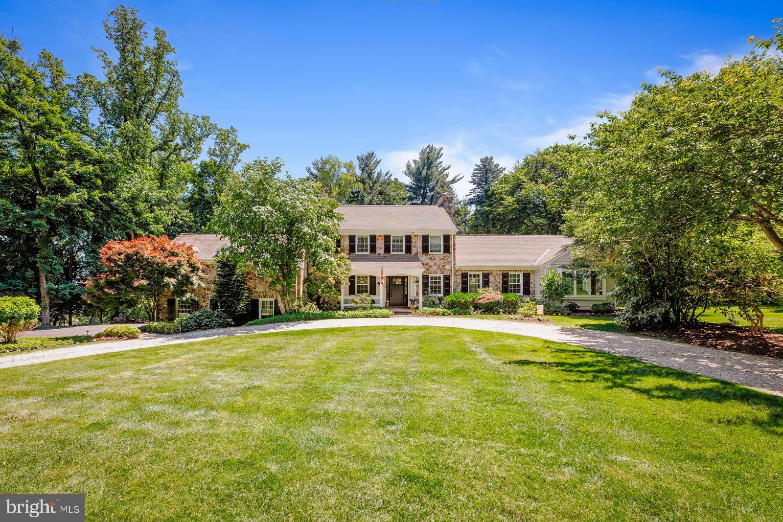 Classic and Timeless Huntingdon Valley Colonial Stone Residence is gracefully situated on one acre of meticulously manicured grounds, approached by a sweeping circular driveway that underscores its stately presence. From the moment you arrive, the home's architectural elegance and commanding curb appeal create an unforgettable first impression. Inside, a dramatic sense of scale and sophistication unfolds. Sunlight pours through expansive windows, illuminating thoughtfully designed living spaces and showcasing the exceptional craftsmanship found throughout. Rich hardwood flooring extends across much of the home, while newly installed windows and doors (2025) flood the interiors with natural light and framed picturesque views of the surrounding landscape. The elegant foyer opens seamlessly into the formal living room, where handsome exposed beams, refined architectural details, and a striking brick fireplace create a warm and inviting atmosphere. Designed for both grand entertainment and everyday comfort, the home flows effortlessly into a spectacular family room that serves as its centerpiece. Featuring a classic fireplace, custom built-in cabinetry, and magnificent floor-to-ceiling windows, this impressive space blends timeless character with modern livability. French doors line one side of the family room, opening to an extraordinary flagstone patio that wraps the home and creates a seamless transition between indoor and outdoor living. At the heart of the residence lies a stunning designer kitchen that is as functional as it is beautiful. Two grand center islands anchor the space, complemented by a professional-grade six-burner range, pot filler, custom ventilation hood, cabinetry, and thoughtfully curated finishes. The sunlit breakfast area overlooks the resort-style pool, offering the perfect setting for morning coffee or casual dining. Nearby, a private light-filled study provides an ideal home office, library, or personal retreat. A first-floor ensuite bedroom offers exceptional flexibility and serves as a comfortable guest suite. The second-level primary suite is a true sanctuary, reflecting both scale and serenity. The luxurious primary bath features a soaking tub, spacious frameless glass shower, marble countertops, and a thoughtfully designed walk-in closet with abundant storage. Three additional bedrooms complete the upper level, each offering hardwood flooring, ceiling fans, generous closet space, and access to a full hall bath. One bedroom features a private walk-out deck overlooking the beautifully landscaped grounds. The finished lower level offers incredible versatility and additional living space, featuring a large recreation room, powder room, dedicated laundry room, mud room, private fitness studio, and a cozy gas fireplace accented by a stunning stone feature wall. A secondary kitchen with cabinetry, sink, and refrigerator makes the space ideal for entertaining, extended guests, or multi-generational living. Outside, the property transforms into a private resort-style oasis. The in-ground pool is surrounded by lush landscaping and complemented by an expansive flagstone patio featuring a stone fireplace, integrated grilling station, and multiple areas designed for alfresco dining and effortless entertainment. Additional highlights include a two-car-attached garage, a three-car detached garage, abundant storage, and parking accommodations for more than ten vehicles. Perfectly positioned, the property offers the ideal blend of suburban tranquility and urban convenience, with easy access to public transportation, major hospitals, top-rated schools, airports, fine dining, shopping, golf courses, and major routes connecting Pennsylvania, New Jersey, Delaware, and New York. A rare offering that combines timeless architecture, luxurious amenities, and resort-style living in one of Huntingdon Valley's most desirable settings. Contact us today!!!