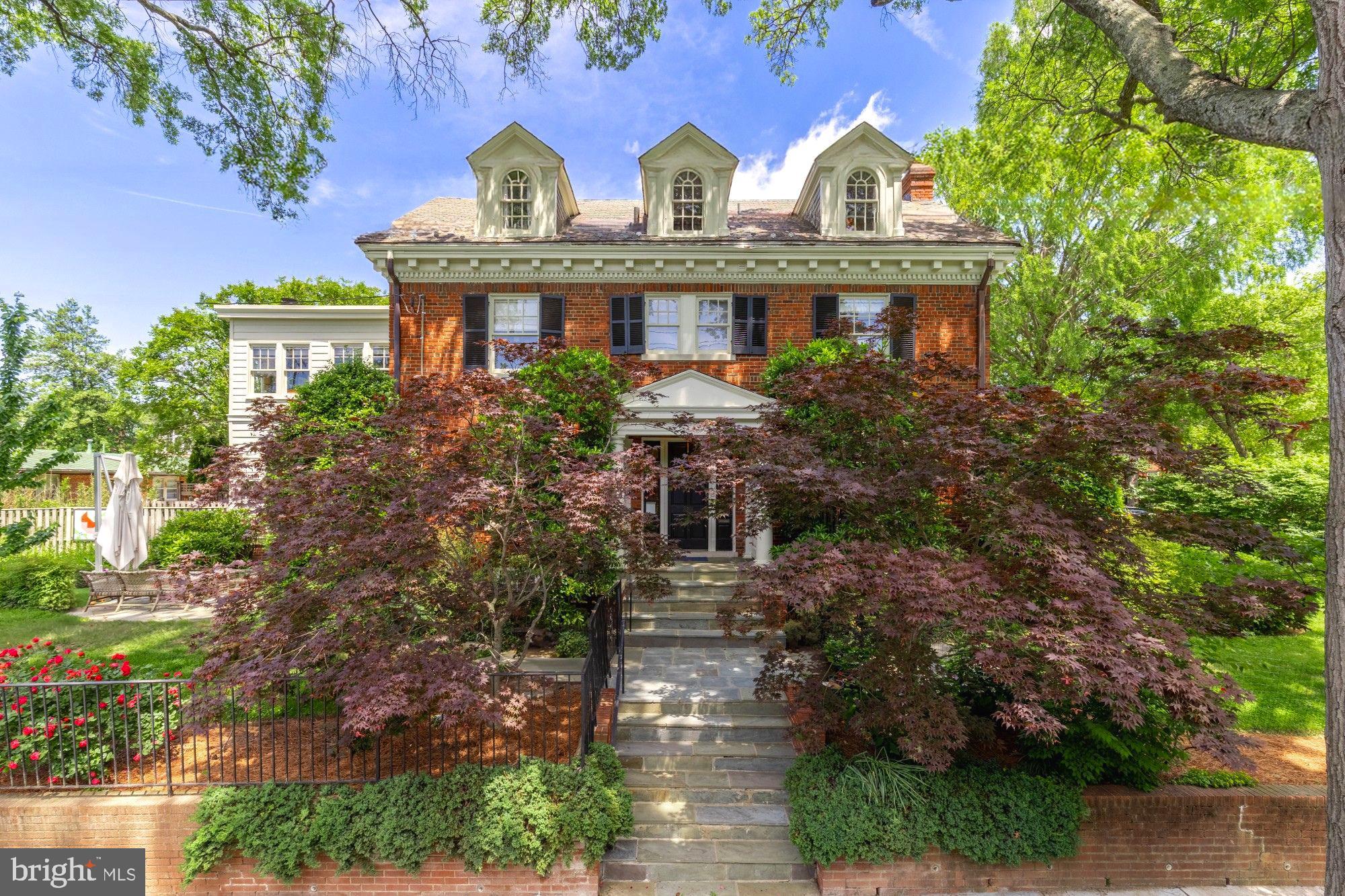 Perched on a prominent corner lot in Woodley Park, this stately colonial blends classic architecture with designer elegance across 6 bedrooms and 4.5 baths. Designed by Annie Elliott, every inch of the home is beautifully curated—from the gleaming hardwood floors to the layered, livable spaces. The formal living room, anchored by a fireplace, flows seamlessly into a light-filled sunroom, while the formal dining room opens to a beautifully updated kitchen and adjacent family room with a second fireplace. Step outside to a gorgeous patio and private backyard, perfect for relaxing or entertaining. Upstairs, the second level features three bedrooms including a generous primary suite and a versatile flex space—ideal as an additional living area or home office. The top floor offers two more bedrooms and a full bath with tranquil views of the National Cathedral. Downstairs, a complete in-law or au pair suite includes its own living and dining areas, kitchenette, bedroom, full bath, and private entrance. Driveway parking with EV charging adds everyday convenience. Located in the sought-after Woodley Park neighborhood, enjoy nearby conveniences like the Washington National Cathedral, Whole Foods, top-rated restaurants, shops, gyms, close proximity to private schools and inbounds Eaton Elementary.