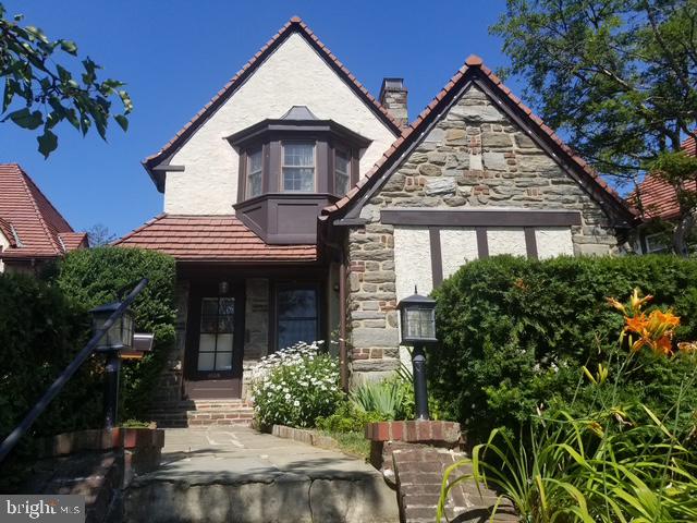 Welcome to 12 Windsor Circle! This charming Tudor is located in a circle of 18 homes,  replicating an Old English community near Windsor, England. It was built in 1927 and has all the beautiful aspects of these historic homes. 
      Walk through the original front door into a spacious living room with hardwood floors and a fireplace. Off one side of the living room is a bonus room complete with recessed lighting that you can use for an office, a playroom, a den or whatever you desire. This room also has private access to the outside. On the other side of the living room, is a doorway into a formal dining room with chair rail. This room also has beautiful hardwood floors. The kitchen has been recently updated with a counter top gas range, a double oven, dishwasher, and a refrigerator. Off the kitchen is a full laundry room/pantry that boasts tons of storage.
     Back to the living room, we head up a beautiful hardwood staircase that leads us to three generously sized, well-lit bedrooms and a full bath. At the end of the hallway, we enter into the primary bedroom with a gorgeous bay window and tons of built-in storage. There is also another full bath en suite. The attic has a hallway access and has tons of extra storage space, not to mention a full unfinished basement that does the same.
     A completely fenced-in rear yard comes complete with a slate patio and beautiful landscaping for privacy and entertaining. You can park in the attached garage or the gated paved driveway. Street parking is also available. This beautiful home is conveniently located 15 minutes from Philadelphia, Philadelphia Airport, and many shopping and restaurant districts.