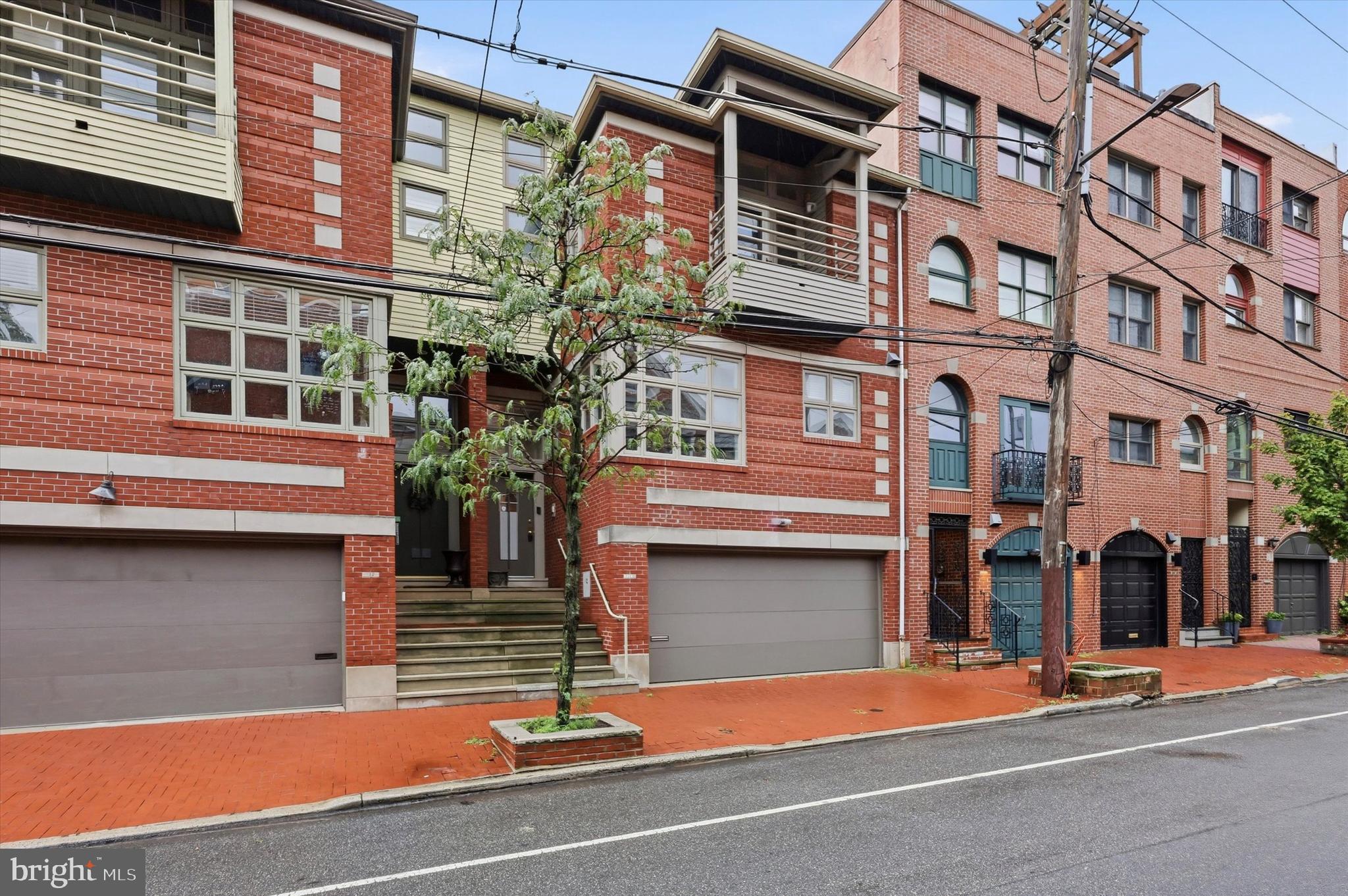Situated on one of Queen Village's most charming tree-lined streets, 114 Bainbridge Street offers an extraordinary opportunity to own a residence where exceptional width, sophisticated design, and everyday functionality come together seamlessly. Spanning an impressive 25 feet wide, this four-bedroom, three full and one half bath home is filled with natural light and features beautifully proportioned living spaces that feel both expansive and inviting—a true rarity in Philadelphia.

Designed for those who love to cook and entertain, the heart of the home is a spectacular chef's kitchen featuring premium Wolf and Sub-Zero appliances, extensive cabinetry, generous prep space, and ample room for gathering around the table. Whether hosting holiday celebrations or enjoying a quiet evening at home, the open, light-filled layout creates an effortless flow between living, dining, and entertaining spaces. Throughout the home, multiple flexible living areas easily adapt to today's lifestyle, offering ideal spaces for a home office, media room, fitness studio, playroom, or additional family room.

The finished lower level adds another layer of versatility, functioning beautifully as a private guest or in-law suite with direct access to a stunning bi-level garden terrace that extends the living space outdoors. A temperature-controlled wine cellar provides the perfect finishing touch for collectors and entertainers alike, while the coveted two-car garage delivers an exceptional level of convenience rarely found in this sought-after neighborhood.

Located within the highly regarded Meredith School Catchment and offering quick access to I-95 and the Ben Franklin Bridge, this exceptional home places the very best of Philadelphia just outside your door. Enjoy an easy stroll to Headhouse Square, Society Hill, and the acclaimed restaurants, cafés, boutiques, and neighborhood favorites that define Queen Village. Combining remarkable scale, timeless style, and an unbeatable location, 114 Bainbridge Street is a truly distinctive city residence.
