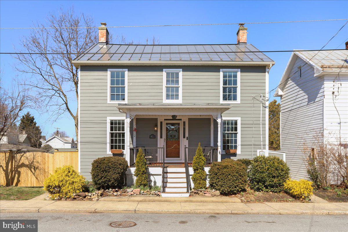 Welcome to this charming farmhouse located in Downtown Walkersville. As you approach, you are greeted by a welcoming front porch with fresh new stain. You immediately notice the timeless architecture that is accentuated by the improved condition in the metal roof and hardiplank siding. Enter into a tastefully updated home with traditional floorplan.  The main level offers an updated kitchen with granite counters, backsplash and stainless appliances. It flows nicely into the dining room, and living room. The living room gets great natural light and is highlighted by the original pine floors. The main level also has a full bathroom and bonus storage/pantry room. The upper level offers a large primary bedroom, two additional bedrooms and a shared full bathroom. The original hardwood flooring has recently been restored and refinished in the living room and primary bedroom. The fully fenced in backyard gives privacy to your spacious back yard and the patio will be perfect for gathering! There is a detached 1 car garage and plenty of street parking in the front of the home. Roof 11 years old, windows 3 years old, heat pump system 4 years old, hot water heater and washer and dryer 2 years old, oil furnace 1 year old. Newly poured concrete foundation, framing and insulation along entire north wall of basement.  Both chimneys were professional capped and the east chimney re-pointed and lined/insulated(furnace flue).  New insulation under main level bathroom. This South facing home gets a ton of natural lighting year round. Just a short walk to a large park and newer library at the end of the street. Close proximity to schools, local shopping and restaurants and major commuter routes. Welcome home!