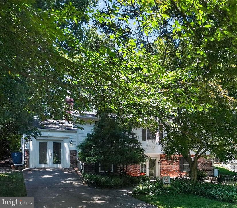 Welcome to this beautifully expanded home in North Bethesda’s highly sought-after White Flint Park/Garrett Park Estates! Tucked away on a quiet, cherry-tree-lined street with lush green yards, this rare NO-HOA property offers peaceful suburban living just minutes from city conveniences. An inviting walkway, framed by charming flower beds and a stone wall, guides you into a spacious, tiled foyer with ample closet space for owner and visitors. The entry level is designed for maximum flexibility. Relax in the cozy family room, highlighted by exposed wood beams and a striking gas fireplace with stately mantel and hearth. Adjacent to the family room is a fantastic bonus space with soaring ceilings, hardwood floors, a built-in loft, and a private entrance off the driveway—perfect for a home office, gym, or guest studio. Also on this level is a sprawling bedroom suite featuring a large closet and French doors that open into a bright sitting, craft, or hobby room with built-in bookcases. A large laundry room, a convenient half bath, and excellent under-stairs storage complete the ground floor. Ascend the stairs to discover gleaming hardwood floors and an expansive, light-filled living and dining area. Down the hall, the primary suite offers a private en-suite bathroom and custom-built closet systems, accompanied by an additional bedroom (also featuring built-in closet storage) and a full hall bathroom. The chef-inspired kitchen looks out on to the backyard. It boasts wrap-around butcher block counters, a gas stove, stainless steel appliances, and newly painted cabinets, added custom cabinetry smartly designed to accommodate taller appliances and display your favorite kitchenware. A pantry and generous under-counter space ensure storage is never an issue. Step through the kitchen's sliding glass doors into your spectacular, triple-section outdoor oasis! Entertain with ease using the dedicated stone-floored grilling area, relax under the covered pergola, or soak up the sun on the open deck. The deep, exceptionally private backyard features natural boundaries, providing an exclusive and serene setting for family and friends. Location is Supreme: Leave the car at home! You are within walking distance of two Red Line Metro stations, the Garrett Park MARC train, bus routes, the world-renowned Strathmore Music Hall, and local parks and bike paths. Enjoy having the vibrant dining and at Black Market Bistro in Garrett Park, shopping and dining at Pike & Rose. Minutes commute from NIH, and Walter Reed plus advantageous access to I-495, I-270, and major commuter routes into Washington, D.C. Furnace and A/C : 2024, Electric Panel: 2021 update sensors for fuses connected to phone, Roof: 2012 (25 year transferable warranty). Updated windows adorned with interior wooden shutters.