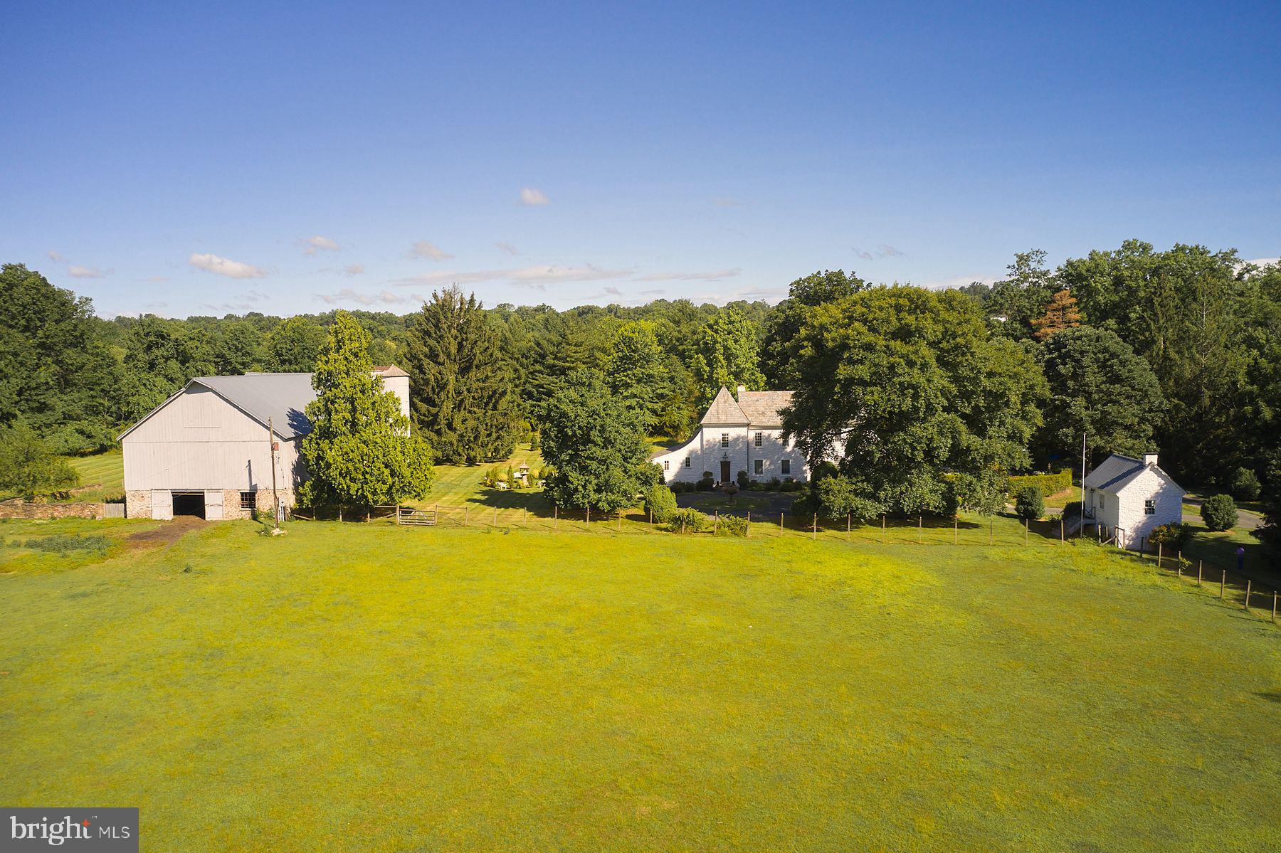 Down a long tree-lined drive find one of Bucks County’s most distinctive historic properties, “DOGS & Frogs”. Built in 1780, this 4 bedroom, 3.5 bath renovated French Normandy-style stone farmhouse features wood-burning fireplaces, antique black walnut flooring, a double- height great room, updated kitchen, and newly built spacious glass family room which opens out to the gardens. Just off the kitchen is a charming, covered veranda which serves the pool area. The Owners Bedroom Suite includes a renovated bath and sumptuous library/sitting room. There are 2 more bedrooms and bath at the second level.  The third level contains a spacious Guest Suite.  The home sits on 10 open acres with mature fields. The property boasts a classic Bucks County stone bank barn which is newly roofed, repointed and heated.   Also find a refurbished stone springhouse which is now the owner’s office overlooking the fields, a carriage shed/garage, and a 2,000 sq ft newly roofed accessory building. For your further enjoyment there is a small pond and garden rooms for gatherings and for the chef/gardener that likes to grow their own vegetables and flowers. The owner currently raises Romney and Lincoln wool-sheep, and keeps horse friends, adding to an old-world feel to the property. Located between New Hope and Doylestown, PA there is plenty of shopping and restaurants that serve an interesting and diverse population. Only 90 minutes from NYC and 45 min from Philly Top public schools in the state and low taxes.