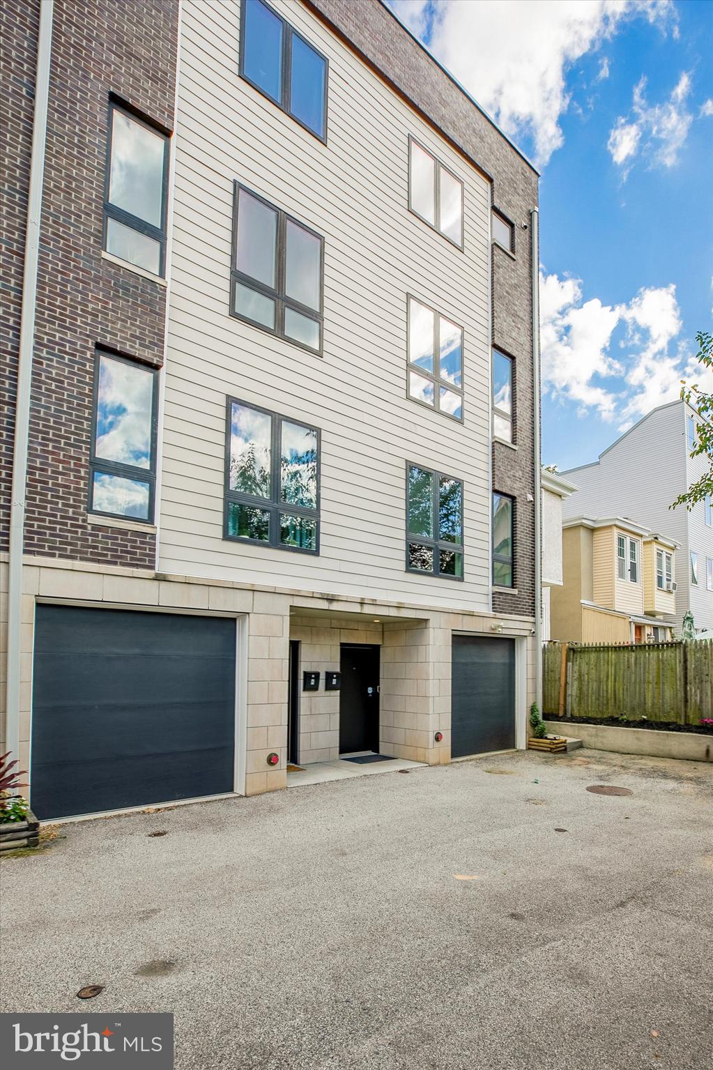 Welcome to this stunning townhouse in prime Manayunk! This newer construction home offers 4 bedrooms and 3.5 bathrooms, with over 3000 square feet of living space. some of the Key features: reserved 2-car parking (1-car attached garage PLUS assigned off-street parking space), Tax abatement, two roofdecks, two facades with separate entrance, Dual zone hvac systems, newly painted, beautiful hardwood flooring, oversized windows and high end finishes.
 
Upon entering from the Terrace Street entrance, you'll find a foyer leading to a long hallway with a coat closet and access to the 1-car attached garage and a large bedroom, which can be used as a home office, home gym, media room, playroom, etc.

The main level features a light-filled open-concept kitchen/dining area with floor-to-ceiling windows and a powder room. The kitchen is equipped with stainless steel appliances, white shaker cabinets, quartz countertops, and an island perfect for daily dining or entertaining. The living room opens to a private front porch, providing a lovely outdoor space.

Upstairs, you'll find two large bedrooms, including a guest suite with an en-suite bathroom featuring a walk-in shower with frameless glass doors and a Porcelanosa double vanity. There is also an additional large bedroom, hall bathroom, laundry area, and storage closet on this floor.

The third floor is dedicated to the main master suite, offering a spacious bedroom with an outdoor balcony, a large walk-in closet, and a spa-like bathroom. The master bathroom features an oversized step-in shower, a luxurious freestanding soaking tub in front of a large window, a Porcelanosa double vanity, and a separate closet. From the pilot house, you can access a wet bar with a wine fridge, a two-sided roof deck with stunning views of the city skyline and beautiful sunsets.

Located on a quiet side street, this townhouse is conveniently close to Manayunk's Main Street, the train, major highways, Kelly Drive, Center City, and the suburbs. It is also near several parks and biking/hiking trails, making it a great choice for outdoor enthusiasts.

This very well maintained and like-new home is a must-see!