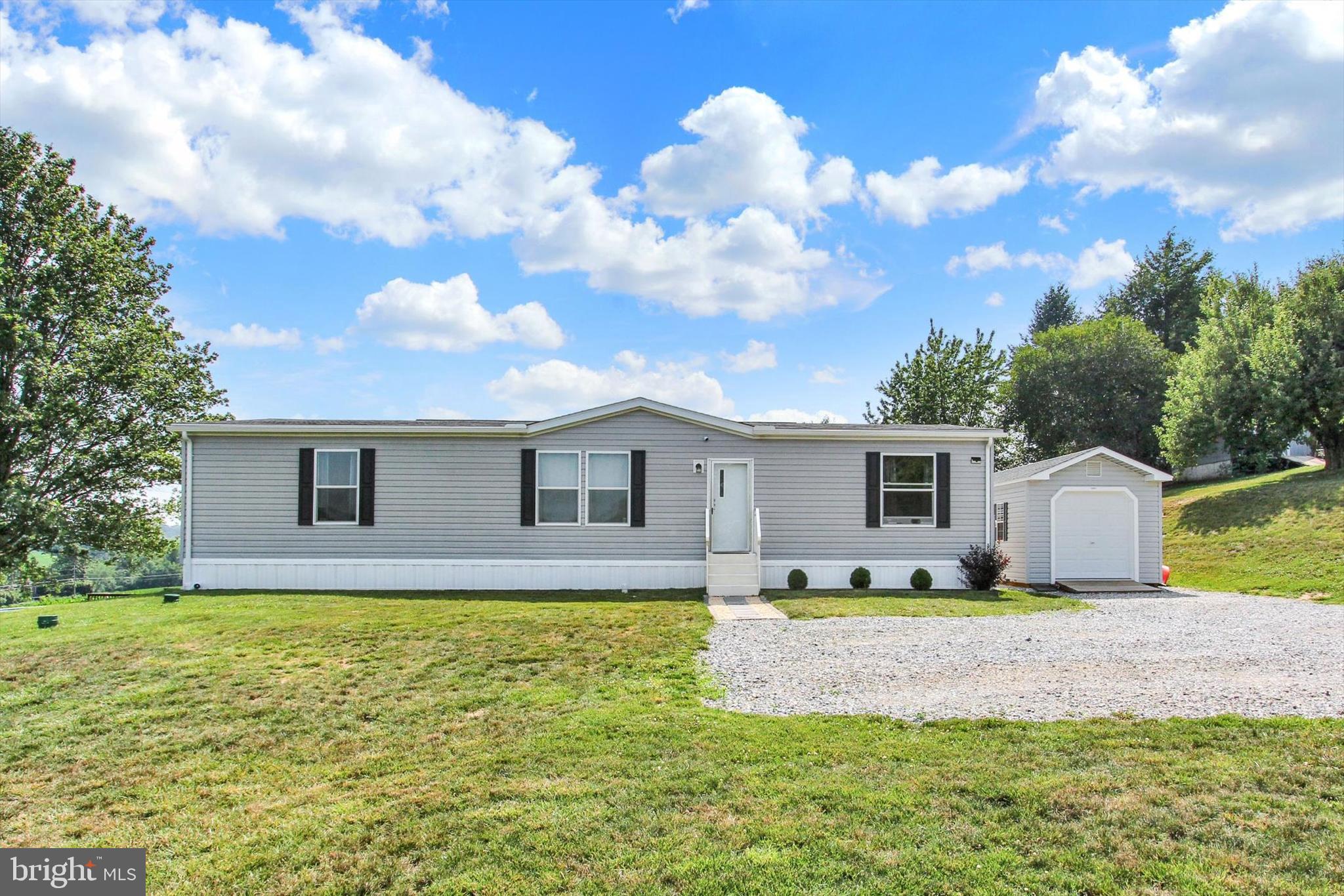Escape to the countryside with this charming 3-bedroom, 2-full bath, manufactured home situated on its own nearly 1-acre parcel, offering tranquil surroundings, serene views, and the ease of single-floor living. All three bedrooms feature walk-in closets, including a spacious primary suite with an attached full bath.

The open-concept layout creates a welcoming flow between the living area and kitchen, where a breakfast bar provides additional seating and gathering space. A separate dining area sits conveniently adjacent to the kitchen, making everyday meals and entertaining effortless. Freshly painted with neutral tones throughout, the home offers a bright and inviting atmosphere ready for your personal touch.

Step outside and enjoy the peaceful countryside setting with picturesque views and abundant outdoor space. Whether you envision adding a patio, porch, garden, or creating the outdoor retreat of your dreams, the possibilities are plentiful. A generous 10x20 shed provides excellent storage for tools, hobbies, or outdoor equipment.

This property offers a wonderful opportunity for those seeking a country escape, a serene weekend retreat, or a place to call home year-round. With nearly an acre of land, there is also potential to build your forever home while enjoying the comfort and convenience of the existing residence. Experience the simplicity, accessibility, and low-maintenance advantages of one-level living in a peaceful rural setting.