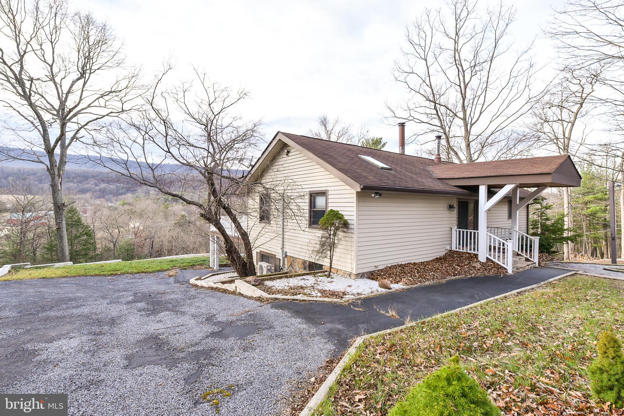 Unique property with tremendous potential on 7.22 acres. The main level features a vaulted family room with a wood-burning fireplace, two bedrooms, kitchen, and a full bath. The views from the  three-season porch are gorgeous!  Enjoy sitting on the deck overlooking the peaceful, wooded surroundings, perfect for enjoying the outdoors.

The walk-out basement offers additional living space, including a family room, office, third bedroom, laundry room, full bath, and multiple storage areas.

A standout feature is the massive 40x60 detached garage with space for numerous vehicles, a workshop area, and more storage. Above the garage is a finished apartment-style space with two bedrooms, a full bath, a kitchen, and a large family room, ideal for guests, extended family, or rental income.

Additional sheds and outbuildings provide even more flexibility for hobbies, storage, or workspace.

Located just minutes from historic Berkeley Springs, this rural property offers privacy, space, and endless potential.

Home is being sold as-is.