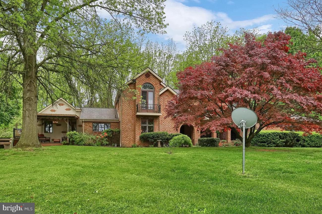 Experience utter peacefulness and serenity in this one-of-a kind home, situated on almost 7 acres, which includes a picturesque pond.   Not in love with the cookie cutter style of so many homes today? Then this unique Tuscan inspired 2-story will be perfect for you!  The first thing you'll notice is the impressive courtyard, featuring a fountain, ceramic tile floor, and striking hardwood ceiling, that leads to the covered brick entryway.  Inside, the roomy foyer flows to a grand living & dining area with beautiful hardwood floors.  This room boasts a wood fireplace with impressive stone surround and hearth, lighted beams, and an open staircase with wrought iron railings.  A full glass panel patio door, flanked by open sidelights and transom, leads to one of the many outside seating areas.  Beyond this room you will find the perfect spaces for all of your entertaining and gathering needs!  The spacious Dellwood custom kitchen includes built-ins and plenty of custom cabinetry with pantry and built-in wine storage, an island with cooktop, and a Jen-Air double oven.  The kitchen with eat-in dining area, is adjacent to the family room.  These areas feature ceramic tile flooring and two sets of French doors, making it easy to enjoy the outdoors and beautiful views this home has to offer   exit one set that leads to a more secluded patio setting, or the other that leads to both a deck and pergola areas.  If the weather isn't cooperating, enjoy a cup of coffee in the charming sunroom, which offers plenty of windows to still enjoy the great views!  Completing the main level is a large study, perfect for office space, a half bath, and a wonderfully functional laundry room.  Upstairs, you'll find the primary bedroom which has an attached bath with soaking tub, a fully renovated shared bath, and two additional bedrooms. All of the bedrooms provide balcony access with more views of the north side of the property.  The lower level with walk-up offers two spacious rooms that provide numerous possibilities!  Plus, two large storage areas.  Attached two-car garage, plus detached 5-car garage with additional storage.  Plenty of space for a workshop if desired!