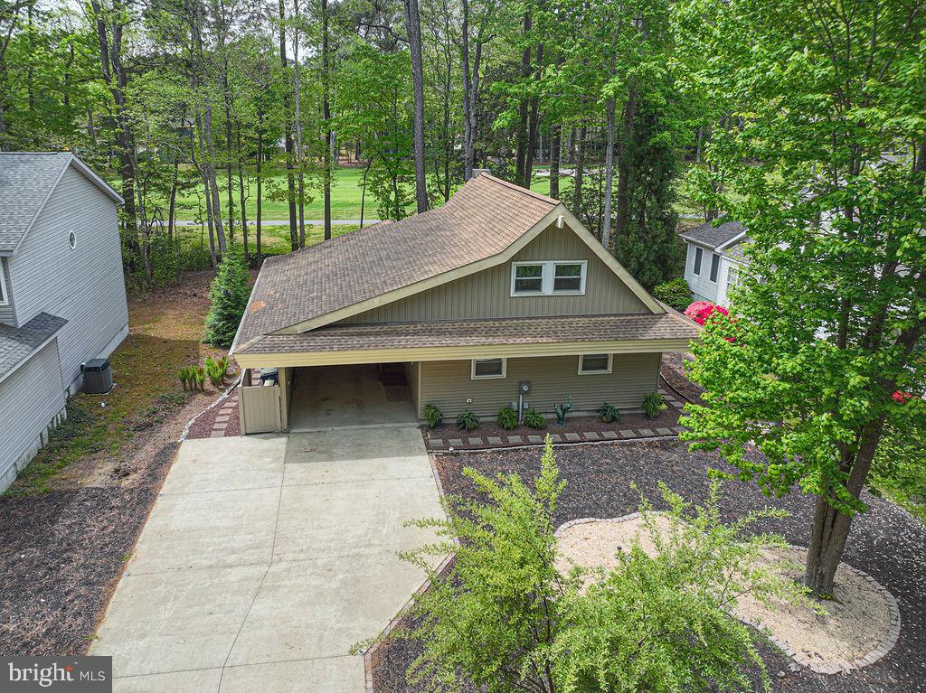 Swiss Chalet charm meets modern coastal living at 62 Newport Dr Ocean Pines Md 
A turn key newly renovated retreat over looking the fourth hole of the famous Robert Trent Jones championship golf course! Beautifully maintained and cared for. With refreshed photos take another look At 62 Newport Dr and the total renovation of this home. It is ideal for a primary residence, a weekend beach-golf escape , or a smart rental investment. When you walk in, the main level features a charming open floor plan with new vinyl plank flooring and an updated kitchen with beautiful stainless steel appliances and new stackable washer and dryer for convenience.The living area has an electric fireplace creating a warm inviting focal point beneath the vaulted ceiling which now includes a new light fixture and a stylish ceiling fan for comfort and ambiance. Two comfortable bedrooms and a full bath on the main level offer flexibility for guests, a home office, or den , all with brand new carpeting , painted throughout with new trim and new 6 panel doors. The upstairs loft features a primary bedroom and full bath with its own Mitsubishi mini split for climate controlled living space. Carpet was installed inside and on the stairs. Over the past four years this home has been completely renovated, including new HVAC system, new thermal pane windows, Doors and updated vinyl siding. Gutters with leaf filters. The roof is from 2018.New plumbing, Hot water heater and updated electric. The house has a whole water filtration system.  The crawl space was partially encapsulated and a new sump pump and dehumidifier were added for climate control. Enjoy peaceful mornings and breezy evenings on the screened in porch taking in views of the golf course among the mature trees of Ocean pines The yard was opened up and installed with new stone and pavers around both front and side yards for easy walking and low maintenance living. Brand new scalloped fencing around the perimeter of the backyard to keep your loved ones safe and secure.llllllllllThere is also room for a small shed in the backyard. The cement driveway holds up to 5 cars which adds exceptional convenience for gatherings and guests and rental stays.The enclosed carport provides sheltered parking that has four electrical outlets suitable for future EV charging. There is also a nice size shed for storage as well as floored eaves for storage on 2nd floor. This Swiss Chalet style home is conveniently located in walking distance to White Horse Park, weekly Farmers market, play ground and the Ocean Pines Community Center, making everyday life and weekend enjoyment incredibly convenient. With its total renovation, golf course setting, walkable location, It is a strong potential as a getaway or income producing property. 62 Newport offers exceptional value at its new price. It’s a one of a kind architectural style and definitely stands out from the rest. Experience the comfort and ease and charm of Ocean Pines living!