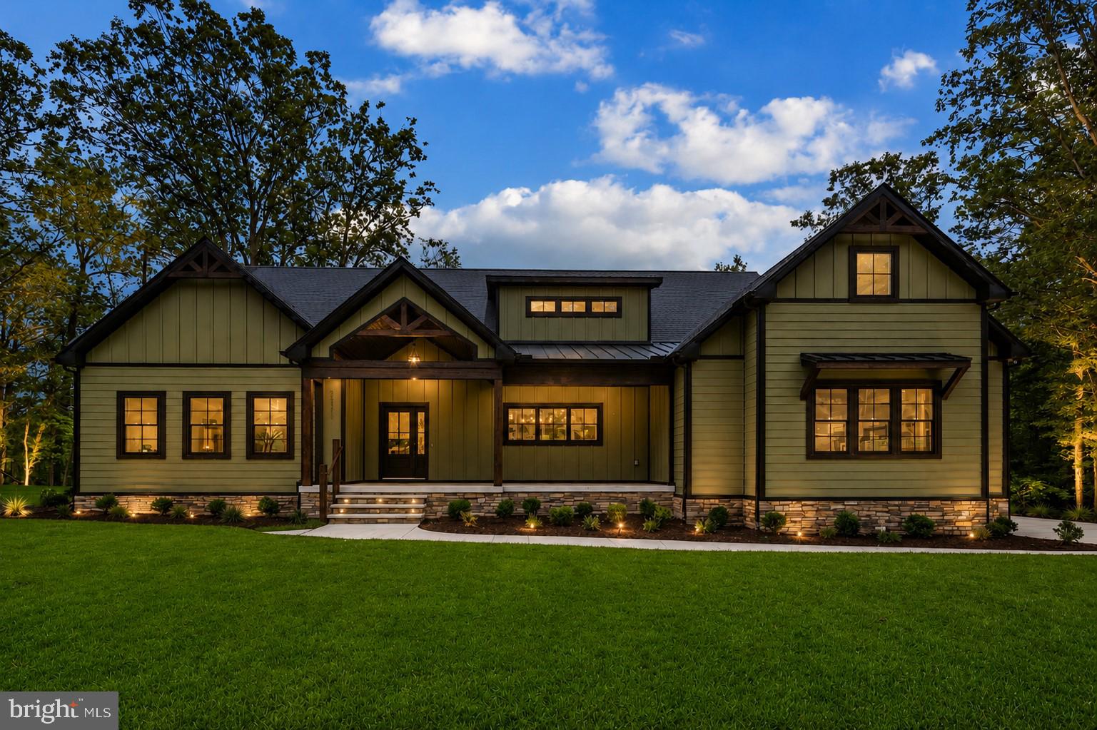 Introducing 24170 Ingrams Drive, an exceptional custom home by Hickory Hill Builders, Inc., thoughtfully designed to blend luxury and timeless craftsman style architecture. Situated on 0.61 acres backing to a protected nature preserve, this distinguished Woodbridge model is surrounded by mature trees and offers stunning views from every angle.

The home's striking exterior showcases a harmonious mix of modern and craftsman design elements, featuring multiple roof peaks, a combination of horizontal and vertical siding accented with stone, eye-catching metal roof details, and professionally designed landscaping supported by an irrigation system. A sweeping walkway welcomes you to the covered front porch, framed by elegant columns and an inviting front entry door with a sidelight panel.

Step inside the impressive foyer, where board-and-batten wainscoting, COREtec luxury vinyl plank flooring, and a sophisticated designer color palette create an immediate sense of warmth and refinement. The open-concept floor plan flows effortlessly into the heart of the home, a stunning gourmet kitchen designed for both everyday living and entertaining.

Anchoring the kitchen is an expansive quartz island with comfortable seating, additional storage, built-in microwave, and elegant pendant lighting. The space is equipped with a full suite of Frigidaire Gallery stainless steel appliances, including a 36-inch six-burner gas range with a statement range hood. Crisp white Fabuwood soft-close cabinetry, detailed trim work, and a stylish horizontal white picket-tile backsplash complete the sophisticated design. A walk-in pantry, accented by a charming barn door, provides abundant storage.

The adjoining dining area is illuminated by a beautiful chandelier and flows seamlessly into the dramatic great room. Here, soaring vaulted ceilings feature reclaimed wood beams sourced from a historic farm dating back to 1906. A stunning double-sided stone fireplace serves as the focal point, complemented by custom shiplap accent walls and creating a warm, inviting atmosphere.
On the opposite side of the fireplace, the sunroom offers a tranquil retreat with vaulted cathedral ceilings, shiplap detailing, and expansive picture windows that frame the picturesque natural surroundings.

The luxurious primary suite is a private sanctuary featuring a vaulted ceiling and a spa-inspired bath. Highlights include dual quartz-topped vanities, a freestanding soaking tub illuminated by a statement chandelier, and an oversized walk-in shower with bench seating, a transom window, rain showerhead, and handheld shower system.

Two additional bedrooms are connected by a beautifully appointed Jack-and-Jill bath, while a spacious bonus room on the upper level provides the perfect setting for game nights, media space, or a private retreat.

The side-entry mudroom is thoughtfully designed with custom wainscoting and hooks  for everyday convenience. The home also features a full unfinished walk-out basement with a powder room, offering endless possibilities for future customization. Sliding glass doors provide access to a patio below, while an elevated composite deck extends the outdoor living space above.

Located within the sought-after Ingrams Point community, residents enjoy scenic nature trails winding through woodlands and alongside serene streams, as well as parks and open spaces that invite endless outdoor recreation. Nearby dining, shopping, and entertainment options are easily accessible, while Delaware's renowned beaches and coastal attractions are just a short drive away.

This is a rare opportunity to experience the pinnacle of luxury living in one of the area's most breathtaking homes. Schedule your private tour today and discover the unparalleled craftsmanship, elegance, and lifestyle that await at 24170 Ingrams Drive.