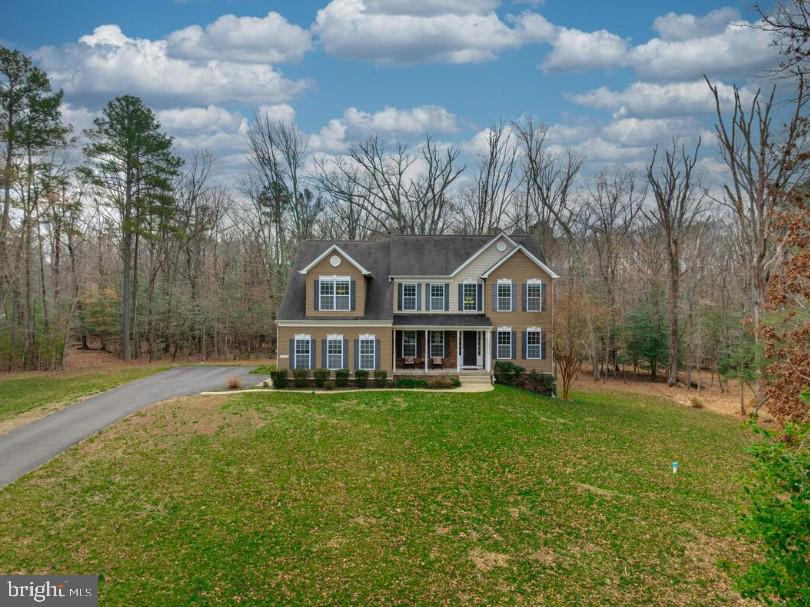 Welcome to this exceptional estate in Hughesville offering space, privacy, and elegant upgrades throughout. Situated on nearly 6 acres and boasting over 5,000 square feet of finished living space, this impressive single-family home combines grand design with everyday comfort.

From the moment you step inside, you’ll be captivated by the dramatic two-story foyer with gleaming hardwood floors that set the tone for the home’s sophisticated interior. The thoughtfully designed open floor plan is perfect for both entertaining and daily living.

The gourmet kitchen is a chef’s dream, featuring granite countertops, stainless steel appliances, wall ovens (including convection), a gas cooktop with a sleek glass range hood, 42" cabinetry, a large island with breakfast bar, walk-in pantry, and a bright morning room that fills the space with natural light. Just off the kitchen, the two-story family room showcases a stunning floor-to-ceiling stone fireplace with recessed lighting above, creating a warm and inviting gathering space. Formal living and dining rooms add elegance for hosting special occasions, while a main-level office/den provides the perfect workspace for today’s professional lifestyle.

Upstairs, the home offers four spacious bedrooms and a hall bath. The luxurious owner’s suite serves as a private retreat with a double tray ceiling, sitting area, walk-in closet, and spa-inspired bath complete with a soaking tub, separate shower with dual shower heads, and double vanities.

The partially finished walk-out basement adds even more versatility with a large recreation room, full bath, and sliding doors leading to a patio. There is also abundant storage and additional unfinished space ready for your vision—whether it’s a media room, gym, or hobby area.

Outdoor living is just as impressive. A large rear deck overlooks the private, tree-lined backyard, while the stone front porch with recessed lighting offers a relaxing place to unwind. The side-load two-car garage includes automatic openers, attic storage access, and a water line for a refrigerator with ice maker. Electrical access outside the garage makes future landscape or driveway lighting easy to install.

Additional highlights include 9-foot ceilings on all three levels, 8-foot doors throughout, hardwood floors on the main level, stairs and upper hallway, and a built-in sprinkler suppression system.

This remarkable home truly has it all—space, luxury, and privacy in a beautiful setting. One visit and you’ll see why this home speaks for itself. Mortgage savings may be available for buyers of this listing.