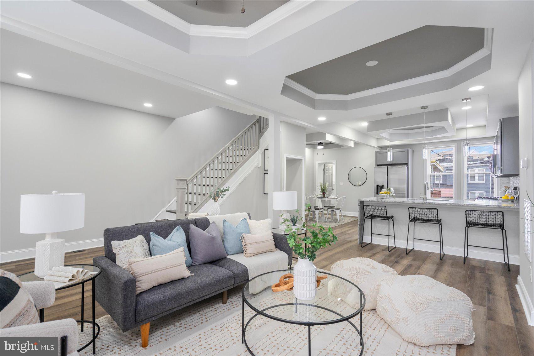 A stunning transformation has taken place behind the door of this 4BR/3.5BA brick Townhome located on a quiet street in Baltimore City.  Make your way through the gated front yard, pass by a lush lawn on the way to the covered front porch of your forever home.  The luxury begins as you step into a beautifully designed main floor featuring custom coffered ceilings , luxury flooring, and recessed lighting throughout the open floor plan.  The spacious living room offers a feature wall hosting a gas fireplace feature with custom built in shelving.  The stunning kitchen and dining room are ideal when hosting family and friends.  The kitchen features plenty of cabinets, stainless steel appliances, granite countertops with a complimenting tiled backsplash, and a stainless sink set into the peninsula with a waterfall edge, pendant lights and breakfast seating for three.  Just beyond the dining room is the main floor laundry and a half bath. The newly carpeted second floor offers two sizable secondary bedrooms, a newly remodeled full bath, and a primary suite.  The spacious primary boasts a private en suite featuring a beautifully tiled walk-in shower. The lower level is finished offering additional living space beginning with new carpeting, the fourth bedroom, a full bath with walk-in shower, a large family room with space for everyone, and a walk-out to a Bilco door in the yard.  From the main floor step outside onto a large wood deck with a covered awning that overlooks the fenced yard offering green space and so many possibilities.  No attention to detail was missed during the creation of this stunning home making it the ideal home for any new homeowner.  Imagine all this and in close proximity to shopping restaurants, and commuter routes.