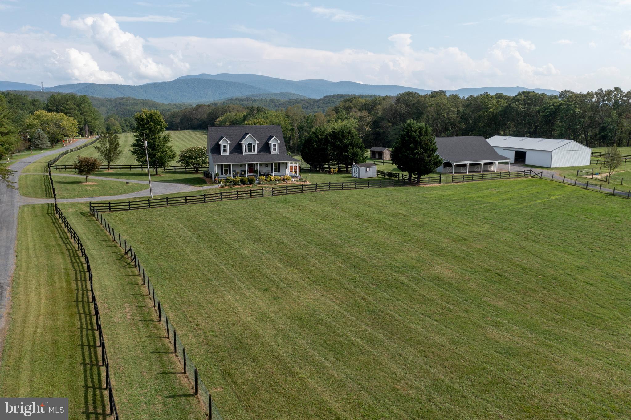 Premier 30-Acre Equestrian Estate Bordering George Washington National Forest. Shown by appointment only, no drive-bys. This is your chance to own this equestrian estate spanning 30 acres in Bentonville, VA, where tranquility meets adventure with unparalleled access to nature and outdoor activities. Bordering the George Washington National Forest on two sides and just a short hike or ride from the Shenandoah River State Park, this property is a haven for both equestrian enthusiasts and nature lovers alike. A six-stall horse barn features a concrete center aisle layout. Complete with a tack room/office, bathroom with hot and cold water, and a spacious hayloft, it offers a seamless blend of rustic charm and modern convenience for horse care and management. Adjacent to the barn, a spacious Conestoga building with skylights and electricity serves as an indoor riding arena, providing a versatile space for year-round riding and training. The arena is complemented by an outdoor riding arena with lights, catering to a variety of equestrian activities. New skylights were installed in 2024. Ensuring reliable water supply, the property includes an agricultural well, essential for sustaining livestock and supplying water to the homestead. Ten meticulously maintained pastures, including four run-ins and five paddocks, are enclosed with 3 & 4 board fencing and no-climb horse fence, prioritizing safety and security for horses. With direct access to the George Washington National Forest, enjoy endless trails for horseback riding, hiking, hunting, and outdoor adventures. The serene backdrop invites exploration and relaxation amidst nature's beauty. Access the Cullers Overlook horseback riding trail within the Shenandoah River State Park, offering picturesque views and a unique opportunity to explore the natural wonders along the Shenandoah River. Historically successful in boarding horses and raising Suffolk, Hampshire, and Polypay sheep, kunekune pigs, and a coop that currently houses a flock of 75 chickens, the property supports a variety of agricultural activities, presenting an opportunity for continued farming pursuits. The traditional 3-bedroom Cape Cod residence has been enhanced with a covered front porch, rear deck, and side deck with a hot tub. A new roof with architectural shingles was installed on house in 2023. Additionally, new AC units for the dual-zone HVAC were installed in 2024, and fencing repairs and painting have enhanced functionality and aesthetics. More recent updates include include new carpet in the primary bedroom and throughout upstairs, new kitchen tile and fresh interior paint. A well pump and hot water heater replacement in 2014 ensure efficient water management.