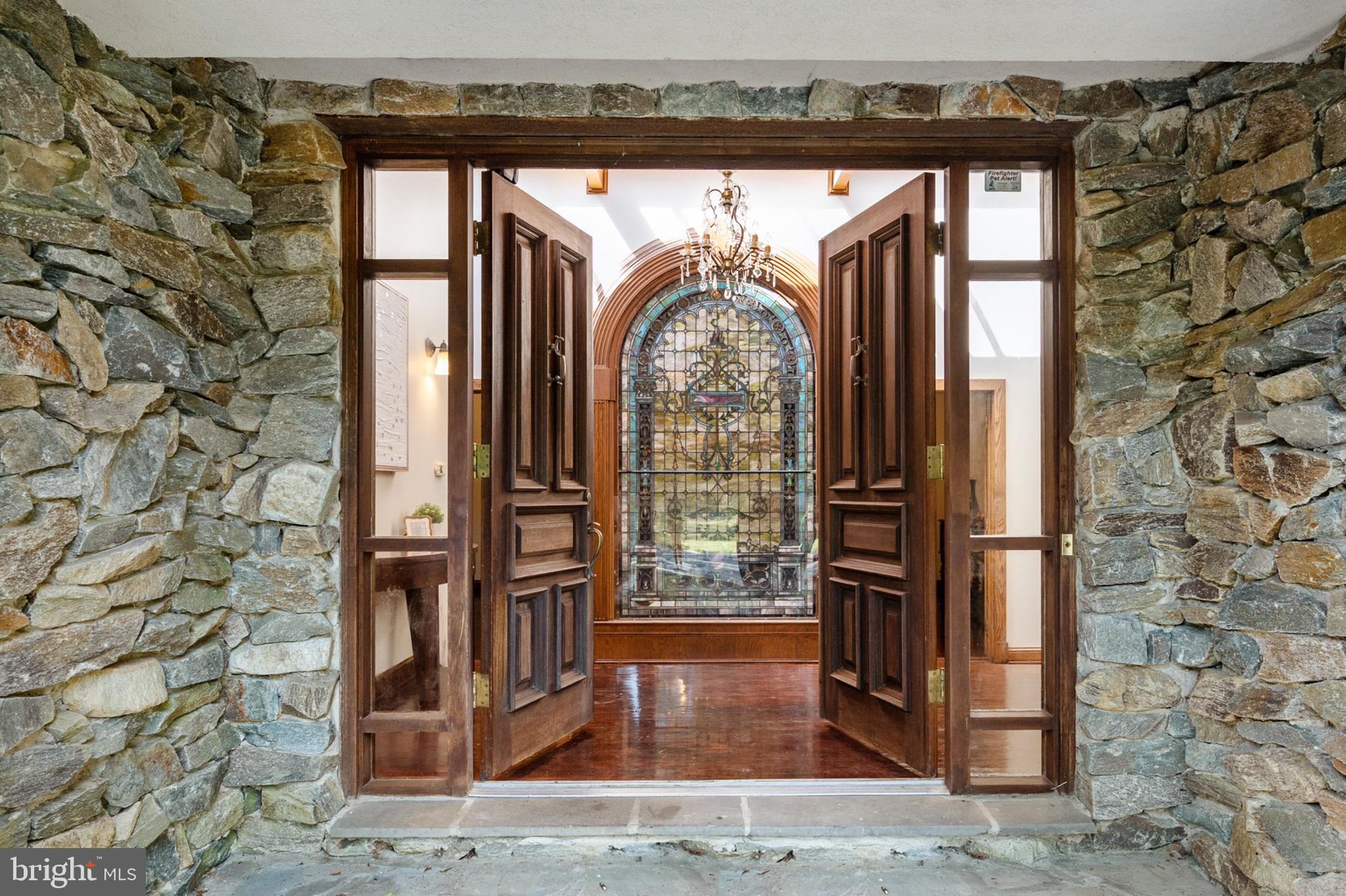 Nestled on a serene 2 acres, this estate provides a haven of tranquility, enhanced by its gated entrance for utmost privacy. 

This stunning Tudor Revival Home boasts 5 Bedrooms and 6.5 Bathrooms, complete with an outdoor In-Ground Pool, Hot Tub, Guest House and 2 Car Garage. Over $300,000 has gone into valuable updates and renovations to create a warm and lavish retreat. 

Entering the home, you are greeted by a grand foyer with chandelier lighting and stunning skylights. The main level was designed with entertaining in mind, offering an open floor plan with gourmet kitchen, formal dining room, family room, great room, sitting room and office. Hardwood flooring exudes timeless beauty, flowing seamlessly throughout the entire main level. 

A true highlight of this remarkable estate is the stunning eight-foot-tall stained glass window, a masterpiece commissioned by the late Lillian Russell. This exquisite work of art serves as a captivating focal point, infusing the home with a sense of elegance and stunning character. 

Experience culinary bliss in the gourmet kitchen, equipped with stainless steel appliances that are crafted within the gorgeous exposed brick. This kitchen features an expansive center island with marble countertops and vaulted ceilings. There are dual sinks, Thermador wall ovens, MicroDrawer, and a Viking cooktop. The additional space for entertaining ties the entire room together and the full size pantry provides excellent storage capabilities. 

Highlighted by a wood-burning fireplace and stunning stained-glass masterpiece, the dining room radiates opulence and sophistication with crown molding throughout. This space is perfect for hosting dinner parties and entertaining guests. The great room is expertly designed and is entirely illuminated by the natural light streaming in through the floor-to-ceiling windows. Enjoy the beauty of the outdoors through the expansive wall of windows, framing beautiful views of the meticulously landscaped gardens, inviting stone patios, hot tub, and refreshing pool. 

Enjoy the beautiful sunroom, where Mahogany flooring, cathedral ceilings and insulated windows combine to create an idyllic space for immersing yourself in the beauty of nature throughout every season. This enchanting space allows you to savor the tranquil ambiance of your new estate.

The primary suite offers a serene and tranquil retreat with vaulted ceilings, gas fireplace and stunning views of the natural surroundings of your private estate. The ensuite bathroom is entirely renovated by the current owners. The entry offers a cosmetic counter with dual vanities and a spacious walk-in-closet. The bathroom itself is an inviting spa setting with a grand glass shower, free-standing contemporary soaking tub, privacy water closet and  amazing views. 

As you enter the lower level through the spiral staircase, you are greeted by a wine cellar, full bar and recreation room with stunning stone floors. Additionally, the lower level features a billiards room with a conveying pool table. The 2 fireplaces on the lower level add warmth and charm, creating cozy gathering spaces on brisk winter evenings. 

A separate area on lower level features stunning built-ins and additional egress with half bathroom, bonus room, and front-loading washer and dryer. You will also find a front-loading washer/dryer on the main level of the home in one of the full bathrooms.  

For those seeking respite and outdoor recreation, a personal in-ground pool awaits, providing an oasis to bask in the sun. Additionally, this outdoor oasis features a gazebo, fire pit and play-set. A guest house with additional kitchen and bedroom stands ready to welcome out-of-town guests, ensuring their comfort and privacy. Every detail has been thoughtfully considered to provide a cozy retreat that reflects warm hospitality.