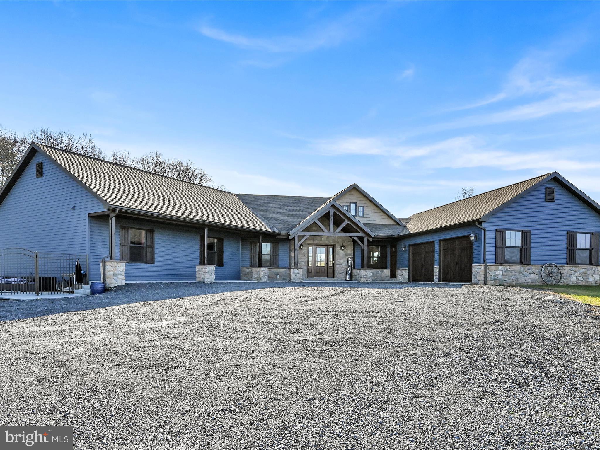 If one floor living and acreage in the country check multiple boxes for you then you MUST see this home.  Nestled off the beaten path this ranch style home on 4.61 acres was newly constructed in 2018.  As you enter through the main entryway your eyes will immediately be drawn to the majestic timber frame and Cathedral ceilings above.  The gorgeous timber was brought in from Tennessee.  Bright and cozy, this open concept living space has so much natural light.  The dining area is spacious and provides plenty of room for  large family gatherings.  The kitchen is a show stopper with a custom island and breakfast bar in a beautiful hue of blue with a butcher block counter.  Neutral cabinetry, granite countertops, custom light fixtures and a large walk-in pantry make this kitchen not only appealing to the eye and functional but  close enough to not miss out on all the family fun.  The sliding glass doors open up to a concrete patio space, perfect for enjoying your coffee in the morning or relaxing in the evening. The primary suite boasts a walk in closet and a spa-like retreat with a soaking tub and tile shower. The five additional bedrooms are spacious with ample closet space. The second full bath features a double bowl vanity and private toilet area. The sitting room could also be used as an office, another bedroom or a hobby/craft room.
The mudroom/laundry area was well thought out with cubbies for coats, bags and shoes.  A half bath here and one just inside the main entrance are conveniently located for a busy family on the go!  The attached two car garage has plenty of space for your vehicles and toys. The two sheds on the property will remain, you can store all of your gardening and yard equipment here.  The fenced in saltwater pool was new in 2020. Imagine relaxing here in the hot summer months!  Don't miss the chance to witness the modern charm and farmhouse elegance of this custom-designed home.  Schedule your private showing today.