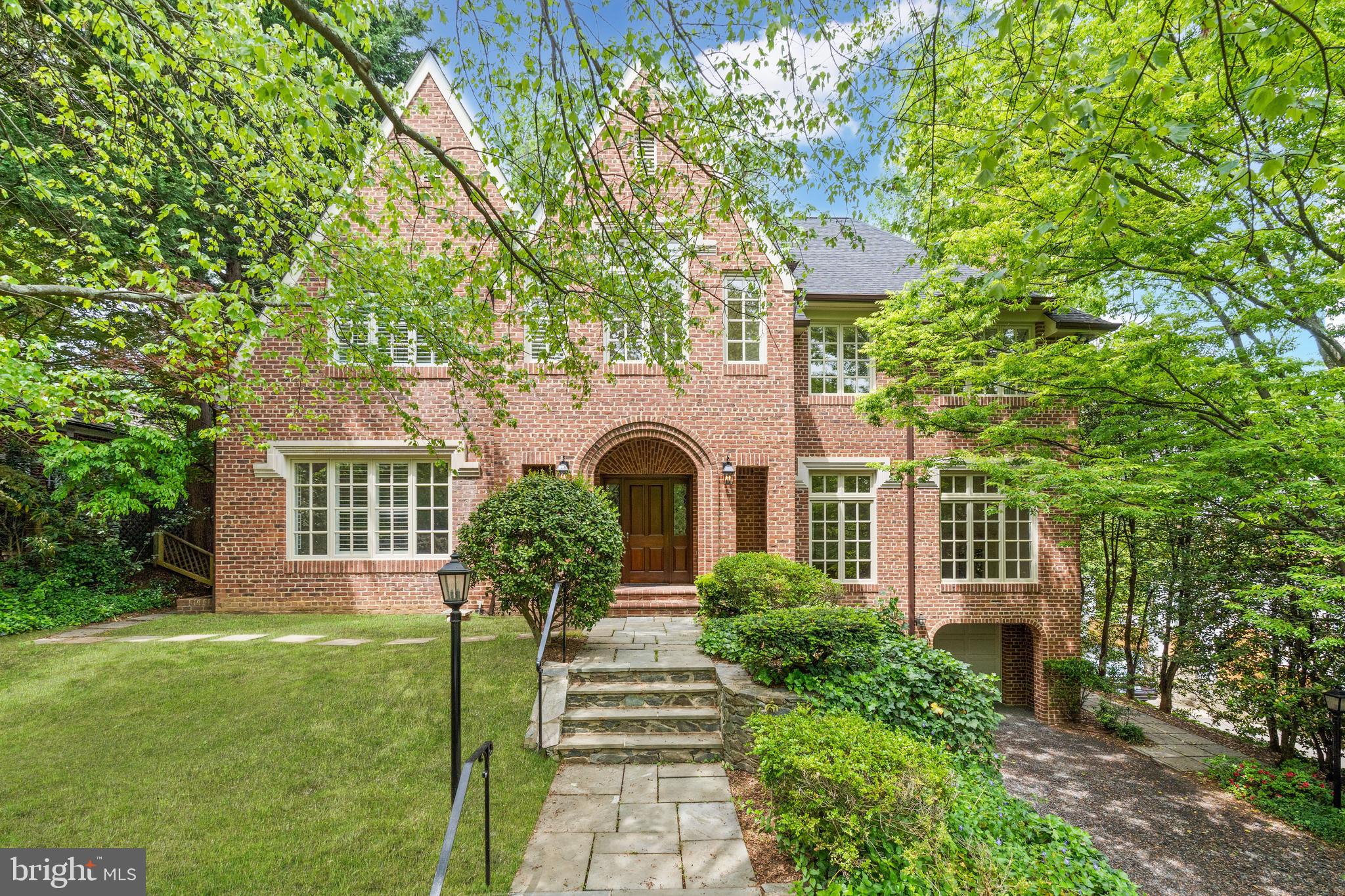 Custom built in 1988 on a large 0.27-acre lot, 4433 Cathedral Avenue presents masterful craftsmanship, refined design, and timelessly curated interiors. This brick Tudor-style home honors its historic architectural integrity while seamlessly incorporating modern upgrades and urban conveniences. Soaring 10-foot and cathedral ceilings, gleaming hardwood floors, walls of windows and numerous skylights accentuate the open-concept home’s incredible scale that extends over 4 fully finished levels. Spanning approximately 8,492 total square feet, the 7 Bedroom, 6 Full Bathroom, 1 Half Bathroom residence has been thoughtfully designed to adapt to its owner’s desires. Outside its impeccable interiors, an enchanting urban oasis awaits. Boasting a walkout rear deck and multiple hardscaped patios, waterfall pond, mature trees, lush landscaping, and pristine gardens encompass the home to provide a private sanctuary in our nation’s capital. Offering the sought-after urban convenience of a 2-Car Attached Garage and additional driveway parking spaces, this Wesley Heights residence is uniquely sited just a few blocks away from restaurants and shopping on New Mexico Avenue, as well as Batter Kemble and Glover Archbold Parks.