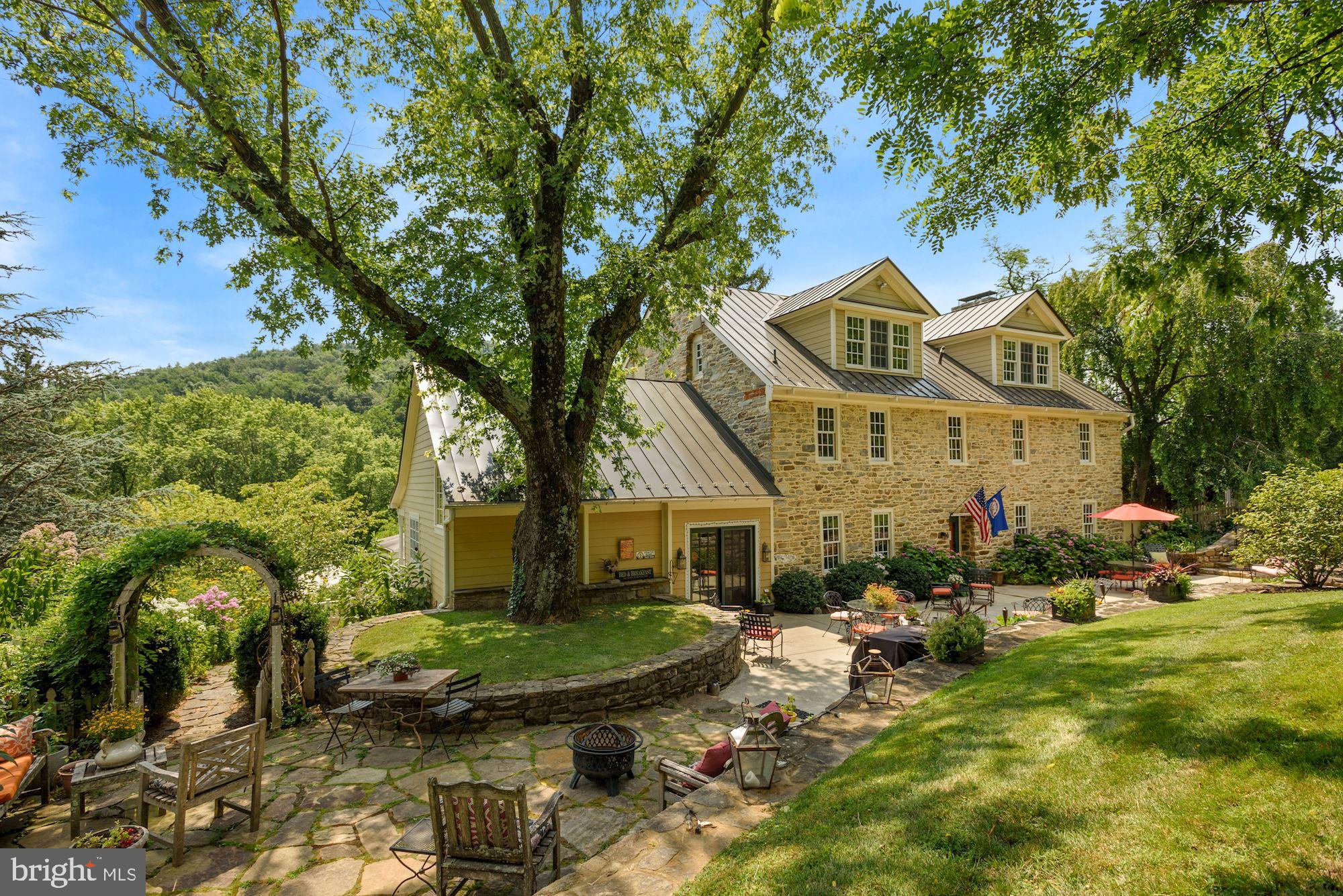 Welcome to Fieldstone Farm (circa 1770), a beautifully restored country retreat located atop a towering stone wall along Charles Town Pike within the Hillsboro Historic District. Sited on 30 acres with commanding Blue Ridge mountains, the Quaker-built stone manor home has been well cared for by its 5 owners during its 251 years of life. Major renovations have included removal of the stucco from the exterior, restoration of the 18” plank heart pine flooring, and an addition of a large gourmet kitchen and great room.

The country retreat offers 6 bedrooms, 3 bathrooms, and multiple living and entertaining areas on 5,600+ SF. The moment you step inside the main residence, it is evident you are in one of America’s most treasured historic homes. The timeworn beauty of the camelback railing on the front hall staircase, original crackling of the four roaring wood-burning fireplaces, 2’ deep walls and windowsills, wide plank hardwood flooring, large rustic stone walls and wooden beams, and plaster walls are rich with history.

Captivating views of the formal gardens, wildflower meadows, koi pond, and mountains are yours to be had from extensive outdoor terraces (seating up to 60 people), two welcoming porches, a heated mountaintop swimming pool with a peaceful waterfall, or various hiking paths.

Located in the heart of the Hillsboro Valley Wine Region, over 20 wineries are within five miles of the farm. Beyond wineries, the surrounding region offers easy access to numerous breweries and distilleries, fine country dining, antique shops, historic landmarks, and W&OD Trail access.

Contact the listing agent for extensive property history. The property is zoned mixed-use and can be used for commercial and residential purposes (see document: Comp Plan Land Use Map Amendments). The property is in land use. The Seller is not responsible for roll-back taxes.
