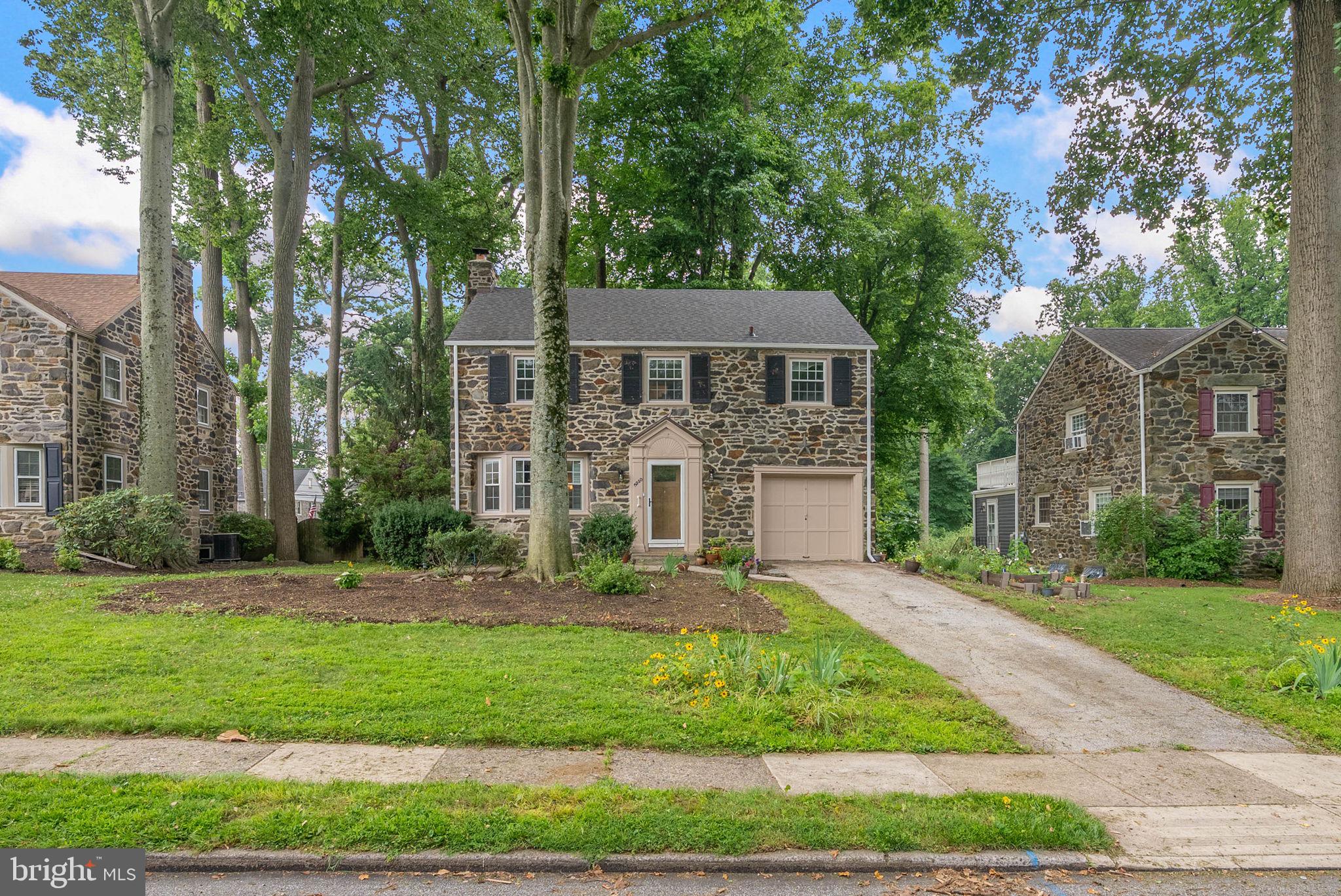 Located on a picturesque, tree-lined street in the highly desirable Pilgrim Gardens neighborhood, this classic stone Colonial offers timeless appeal in a wonderful setting to call home. Situated on a spacious lot with a fenced backyard, deck, and patio, the property provides plenty of room for outdoor entertaining, gardening, play, or simply relaxing.

Inside, the home features a traditional floor plan with a welcoming living room complete with a fireplace and bay window, a formal dining room overlooking the backyard, and an eat-in kitchen with direct access to the rear deck and patio. The second floor offers generously sized bedrooms, including a spacious primary suite with its own private bath.

The finished lower level features a built-in bar and provides flexible space for a recreation room, home office, gym, or playroom. An attached one-car garage adds everyday convenience.

Conveniently located near shopping, restaurants, parks, public transportation, Route 1, I-476, and Center City Philadelphia, this home offers the perfect combination of location, space, and classic charm in one of Drexel Hill's most sought-after neighborhoods.