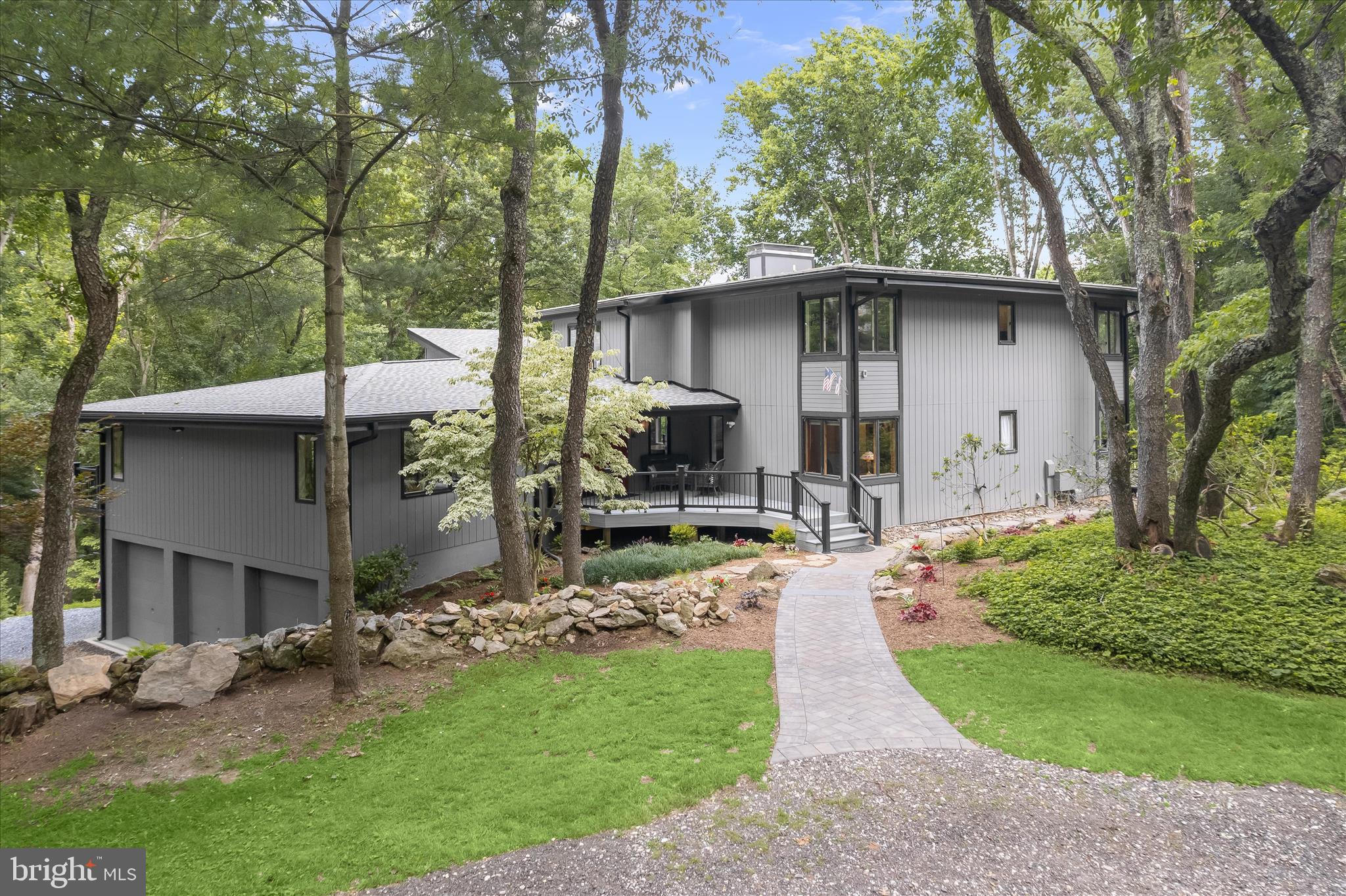 Welcome to 13365 Forsythe Road, a truly exceptional custom-built residence thoughtfully situated on five breathtaking acres directly touching the Hugg-Thomas Wildlife Preserve. Meticulously maintained and extensively renovated, this one-of-a-kind passive solar home was professionally designed and oriented seven degrees east of true south to maximize natural solar heat gain during the winter months, seamlessly blending environmental efficiency with architectural beauty.
Surrounded by mature trees, a peaceful stream, stunning natural landscapes, and custom hardscaping, this remarkable property offers a private sanctuary where nature and luxury coexist in perfect harmony.
Inside, the welcoming foyer features custom inlaid porcelain tile flooring and an inviting reading nook with tranquil woodland views. The living room showcases soaring wood ceilings accented by cove lighting, creating warmth, character, and an unmistakable sense of comfort. At the heart of the home is the beautifully renovated eat-in kitchen, designed for both everyday living and effortless entertaining. Enjoy picturesque views from every window while preparing meals surrounded by quartz countertops, a center island, soft-close cabinetry, a convertible double oven, top-of-the-line stainless steel appliances, decorative backsplash, and a bright dining area with direct access to the rear deck overlooking the scenic grounds.
The dramatic great room is anchored by an impressive two-and-a-half-story North Carolina rubble stone fireplace and enhanced by soaring ceilings that create a grand yet welcoming atmosphere. Floor to ceiling windows with built-in bench seating invites relaxation, while a distinctive vintage oak claw-foot dry bar with a brass countertop and water rough-in adds charm and functionality. A private office, which can also serve as a main-level bedroom, features custom built-ins and is complemented by a full bath, completing the main level.
Overlooking the great room below, the upper level is highlighted by a luxurious primary suite featuring interior viewing panels that open to the great room, a private balcony, a spacious walk-in closet, and a beautifully renovated spa-inspired bath adorned with exquisite tilework and a large walk-in shower. Two additional bedrooms and a beautifully renovated full bath complete the upper level.
The finished lower level offers even more versatile living space with a recreation room centered around a cozy wood-burning stove, creating the perfect setting for gatherings, hobbies, or quiet evenings at home. A bonus room with built-ins, a second staircase, direct access to the three-car garage, and abundant storage further enhance the home's functionality.
Throughout the residence, standout features include solid mahogany doors, luxury vinyl plank flooring, soaring ceilings, Andersen casement windows, a variable-speed well pump, and an efficient three-zone HVAC system designed for year-round comfort and energy efficiency.
The exterior is equally impressive, blending seamlessly into its natural hillside setting. Moss-covered landscape features, a circular driveway, a front Trex deck, and a versatile outbuilding originally constructed for kiln use contribute to the property's unique character. Distinctive metal and skillion rooflines create striking architectural interest while complementing the surrounding environment.
Recent improvements include luxury vinyl plank flooring, epoxy-coated garage floors, new basement flooring and carpet, a renovated kitchen and bathrooms, a variable-speed well pump installed within the past four years, a three-zone HVAC system, and an architectural shingle roof approximately three years old.
Offering unparalleled privacy, thoughtful design, energy-efficient passive solar construction, and direct access to the beauty of the Hugg-Thomas Wildlife Preserve, this extraordinary property is also conveniently located near Routes 32, 97, and 70. Enjoy easy access to historic downtown Sykesville, rece