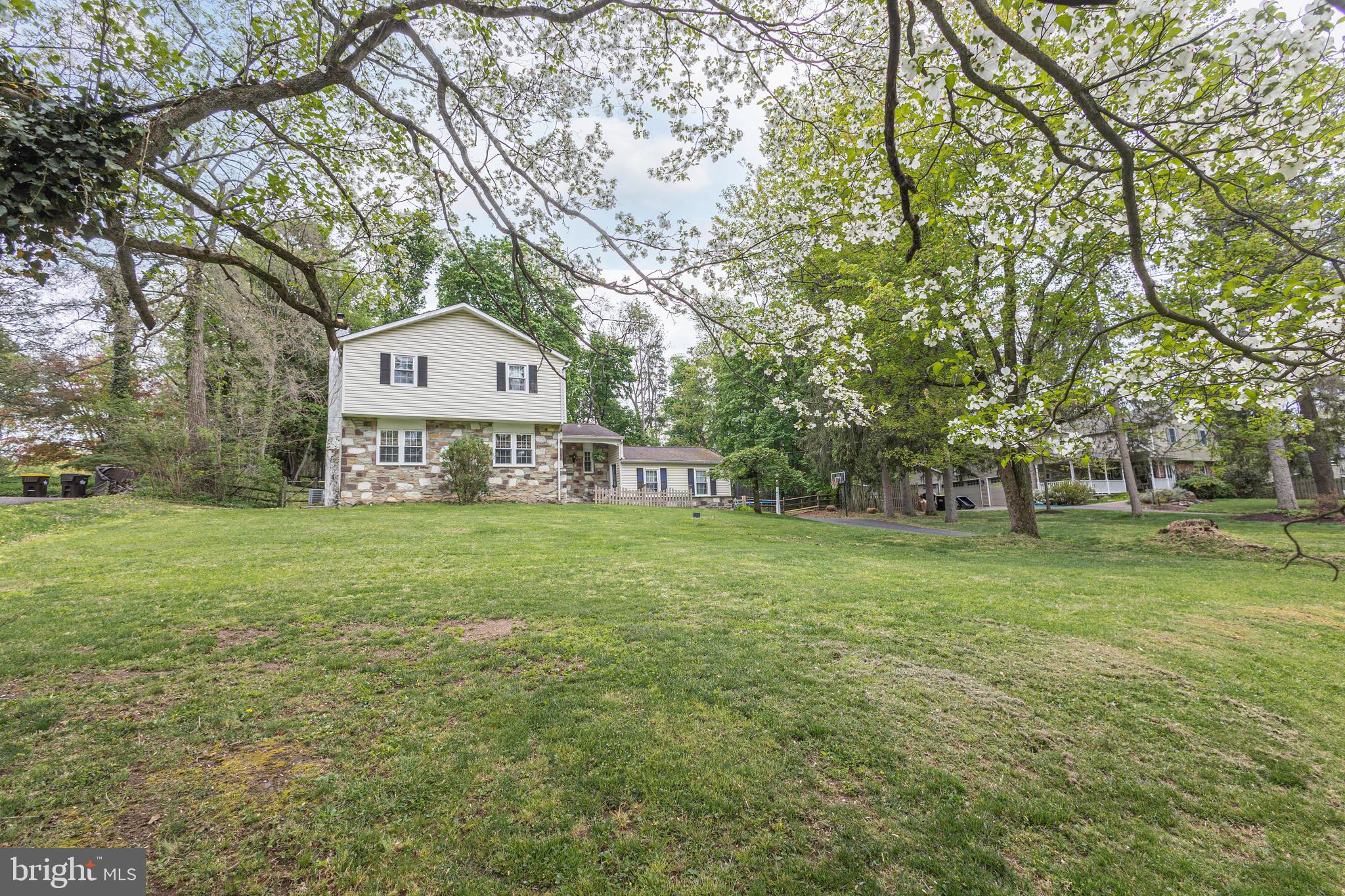Located on nearly an acre in the desirable Pebble Hill community, this quaint colonial home is set back from the road to offer peace and quiet with a natural backdrop. Thoughtfully updated with refined upgrades, a neutral color palette that exudes comfort throughout. Charming stone steps lead to the covered porch for watching sunsets. Upon entering the foyer, hardwood floors extend seamlessly throughout the living spaces, creating a warm and cohesive ambiance. The stunning new custom kitchen, tastefully updated in 2026, showcases crisp white cabinetry, sleek quartz counters, stainless steel appliances, a farmhouse sink, neutral tile backsplash, and stylish light fixtures. Gather around the island with loved ones or enjoy the view from the sunny breakfast nook. The spacious living room is anchored by a striking stone fireplace with an electric insert, adding to the home’s cozy appeal, while the dining room offers an ideal setting for entertaining. The calming sunroom with vaulted ceiling, skylight, windows, and sliding doors frames tranquil natural scenery. Step out onto the newly refurbished, sprawling deck, primed this week to be stained prior to showings. A spacious mud room with laundry and closet space, a powder room, and a garage with abundant storage complete the main floor. Hardwood floors continue upstairs and into all four bedrooms. The primary bedroom is filled with natural light and features two closets and a renovated en suite bathroom (2023) with tile shower, newer vanity, and pebble tile flooring. Three additional spacious bedrooms share an updated hallway bathroom with dual vanity and bathtub shower. The lower level offers flexibility to suit your needs, whether for extra storage, a fitness area, or recreation. The outdoors is your sanctuary, as the property backs to trees and a glimpse of a neighboring stone bank barn from the 1700s, filtered through the greenery. Beyond the private fenced-in backyard, a strip of land belonging to 71 Oak Road connects this property to Turk Road, part of the old wagon trail into Doylestown Borough. NATURAL GAS, a newer water heater (2024), water filtration through a UV light filter, replacement windows, and replacement septic system (installed 2003) provide added peace of mind. From the property, take the bike trail 1.5 miles to Central Park to experience Kids Castle, pickleball and tennis courts, and the newly opened rec center. Assigned to the award-winning Central Bucks School District and only 1.5 miles from State and Main Streets, 71 Oak Drive offers a true sense of retreat and an unmistakable feeling of home.