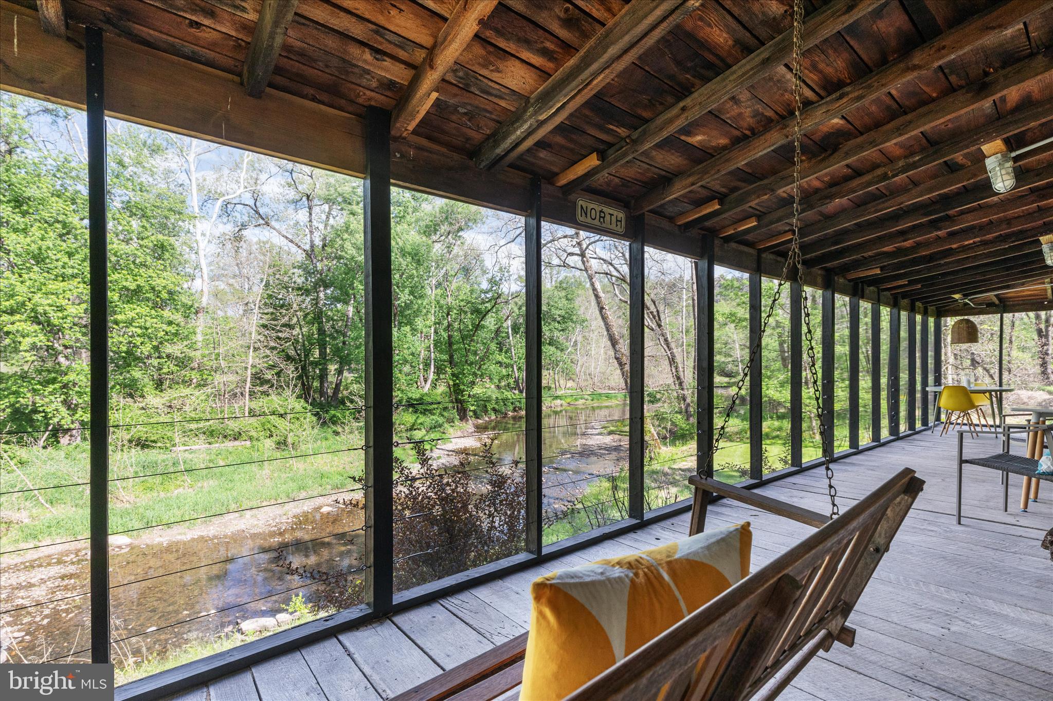 One-of-a-kind riverfront living, where the rhythm of the Cacapon River becomes part of everyday life.
Set on just over two private acres, this 1-bedroom, 1-bath log cabin offers a rare blend of rustic charm and thoughtful updates, with an additional bunkhouse that creates space for guests, gatherings, or slow summer weekends that stretch a little longer than planned. Tucked just off a paved state road, access is easy—but the feeling is worlds away. Inside, the fully furnished cabin holds onto its character. A large stone, wood-burning fireplace anchors the living space, while warm wood tones and natural textures reflect the landscape just beyond the windows. The kitchen has been carefully refreshed with quartz countertops, updated appliances, and modern lighting—bringing a clean, functional contrast to the home’s classic log construction.
Step out to the screened porch, where the river becomes the focal point—steady, calming, and always changing with the seasons. It’s the kind of place that invites morning coffee, afternoon reading, and long conversations well into the evening. Recent improvements (2021–2022) have already been handled—from a new black metal roof and chimney liner to siding repairs, insulation, updated electrical, and refreshed outdoor spaces—allowing for a more seamless transition into ownership. Beyond the main cabin, the bunkhouse and open yard create a natural extension of the home. A fire pit, picnic area, and direct access to the river set the stage for swimming, fishing, kayaking, or simply sitting still and listening.
Previously enjoyed as a successful short-term rental, the property also offers high-speed DSL internet and even includes a monthly utility credit—adding both practicality and value. Located just minutes from the small-town charm of Wardensville, with easy access to Winchester and the greater DC region, this is a place that works equally well as a weekend escape, an investment, or something more permanent. Some properties check boxes. Others create a feeling. This one does the latter. Schedule your appointment today!
