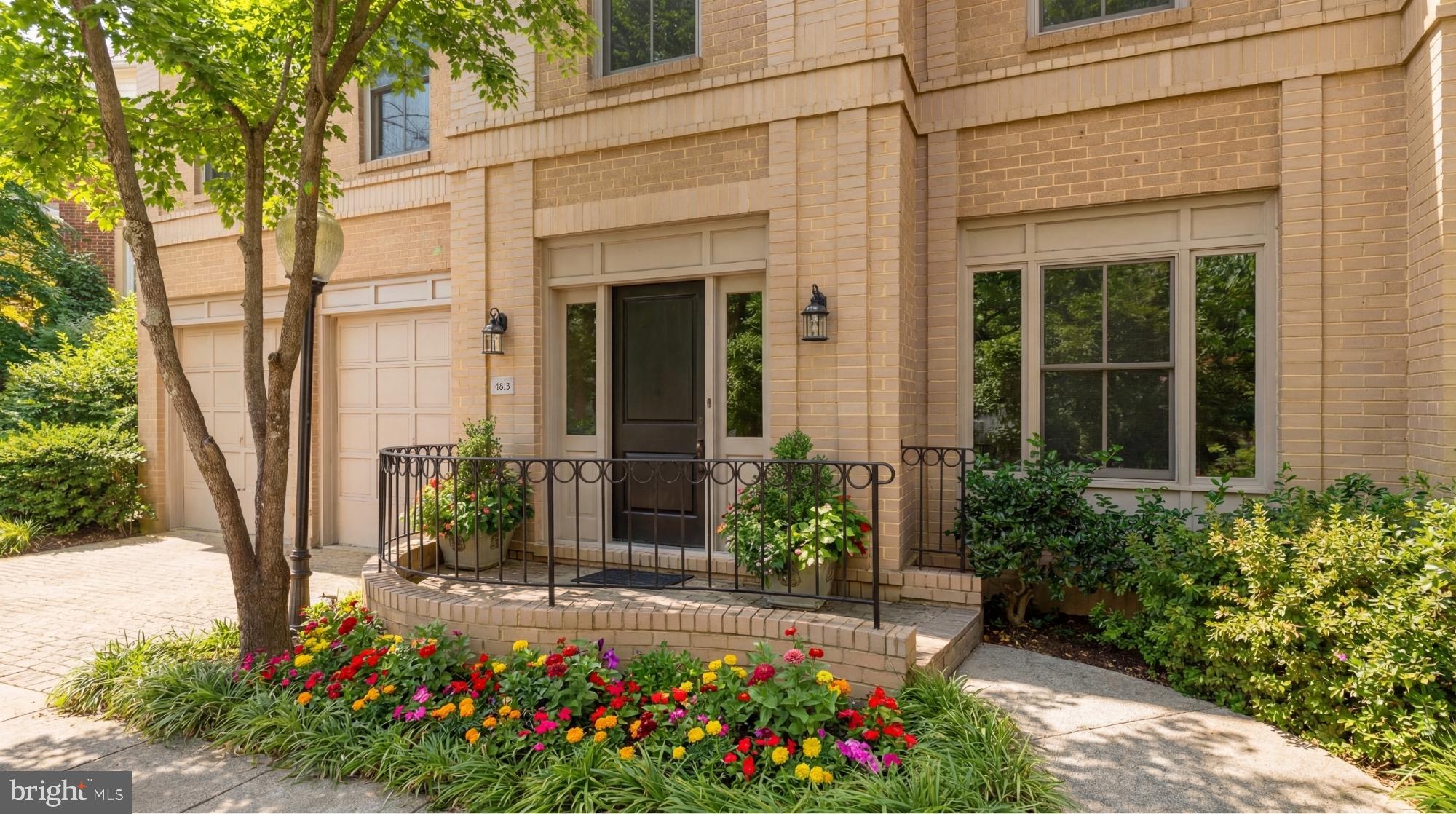 The Berkley neighborhood residences are  synonymous with quiet luxury and restrained elegance. Nestled within the newest section of  Battery Kemble Place, this distinguished enclave, on the site of the former Rockefeller Estate, is 4813 Kemble Place.  The home is a classic brick colonial blending traditional principles with modern livability. Perfectly symmetrical, the facade evokes cues from classic estates of the past. Inside, the central entry hall creates a formidable initial impression, with gleaming Carrara marble floors and a sweeping grand staircase. Detailed plasterwork throughout the main level consists of thick, carved crown moldings and archways framed by columns. Formal rooms are generously proportioned. The dining room is embassy sized, with two walls of glass and access to a private balcony for al fresco entertaining during the warmer months. A substantial living area in the rear spans the entire width of the home. Lavishly appointed yet still warm and intimate, the space features accent lighting and is anchored at one end by an intricate, roaring fireplace. A wall of double casement windows and access to a second private balcony complete the area. Upstairs, the primary suite is accessed through double doors. The large sleeping area connects to a five-piece marble bath and walk-in closet space. Secondary bedrooms are each ample in both scale and storage. The grand staircase leads to the walkout lower level in a gracious arc. Sitting above grade, the ethereal space is flooded with natural light. A large recreation room features extensive built-ins on two walls, flanking a roaring fireplace. A professional, mirrored fitness room and guest bedroom complete the space. Shaded by verdant foliage and shrouded in privacy, the rear lawn offers usable green space. Convenient to Georgetown, Downtown, and major commuter routes, 4813 Kemble Place is an exemplary residence in one of DC’s most sought-after locations.