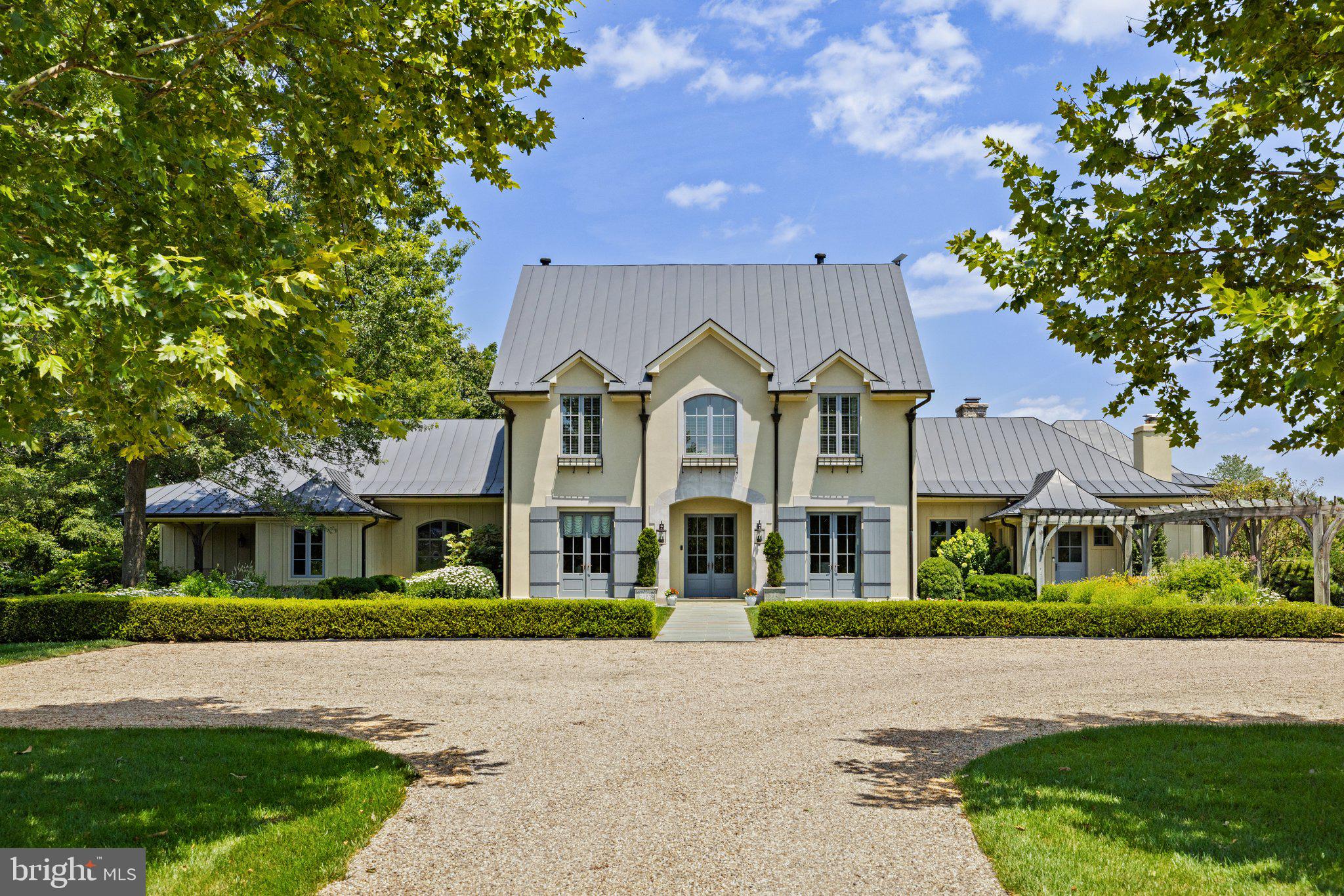 Welcome to Tanner Branch Farm, an exquisite 85+acre country estate in Marshall, VA. This exceptional property offers the perfect blend of luxurious living, natural beauty, and outdoor recreation. 
Bordering the picturesque Tanner Branch, the 9,200+ square foot home has been meticulously updated and expanded. It boasts a sumptuous main level Primary Suite with a luxurious en suite bath, a private sitting room with a cozy fireplace, and access to a tranquil fountain and stone patio. Throughout the home, you'll find walnut hardwood floors, eight fireplaces, some adorned with French limestone mantels, and a handsome library with custom built-ins and beautifully paneled walls. The spacious gourmet kitchen is a chef's dream, and the family room addition features soaring beamed ceilings and an abundance of natural light. Working from home or streaming is a breeze with the Starlink internet service, providing high speed up and download speeds.  
The lower level is an entertainer's paradise, complete with a bar crafted from ribbon mahogany, a true work of art. The bar area opens to the inviting pool deck. Additionally, there's a media room with a state-of-the-art sound system and an au pair suite. For a detailed list of upgrades and features, please refer to the comprehensive document provided.
The property also includes a well-appointed 6-stall horse barn, perfect for equestrian enthusiasts who can explore the nearby 1000-acre Hume Trail Network or enjoy riding through the estate's trails. Upstairs in the barn, a guest house awaits, built with meticulous attention to detail. It features old wood beams imported from Oregon, hickory floors, a gourmet kitchen with a spacious island, and two bedrooms.
At Tanner Branch Farm, you'll revel in the beauty of the countryside, from swimming in the pool to hiking the wooded trails, from horseback riding through the Virginia Countryside to dining al fresco on one of the numerous patios or verandas. Enjoy breathtaking sunrises and sunsets in this private retreat, a sanctuary where wildlife and nature abound. Tanner Branch Farm is your opportunity to experience the epitome of country living at its finest.