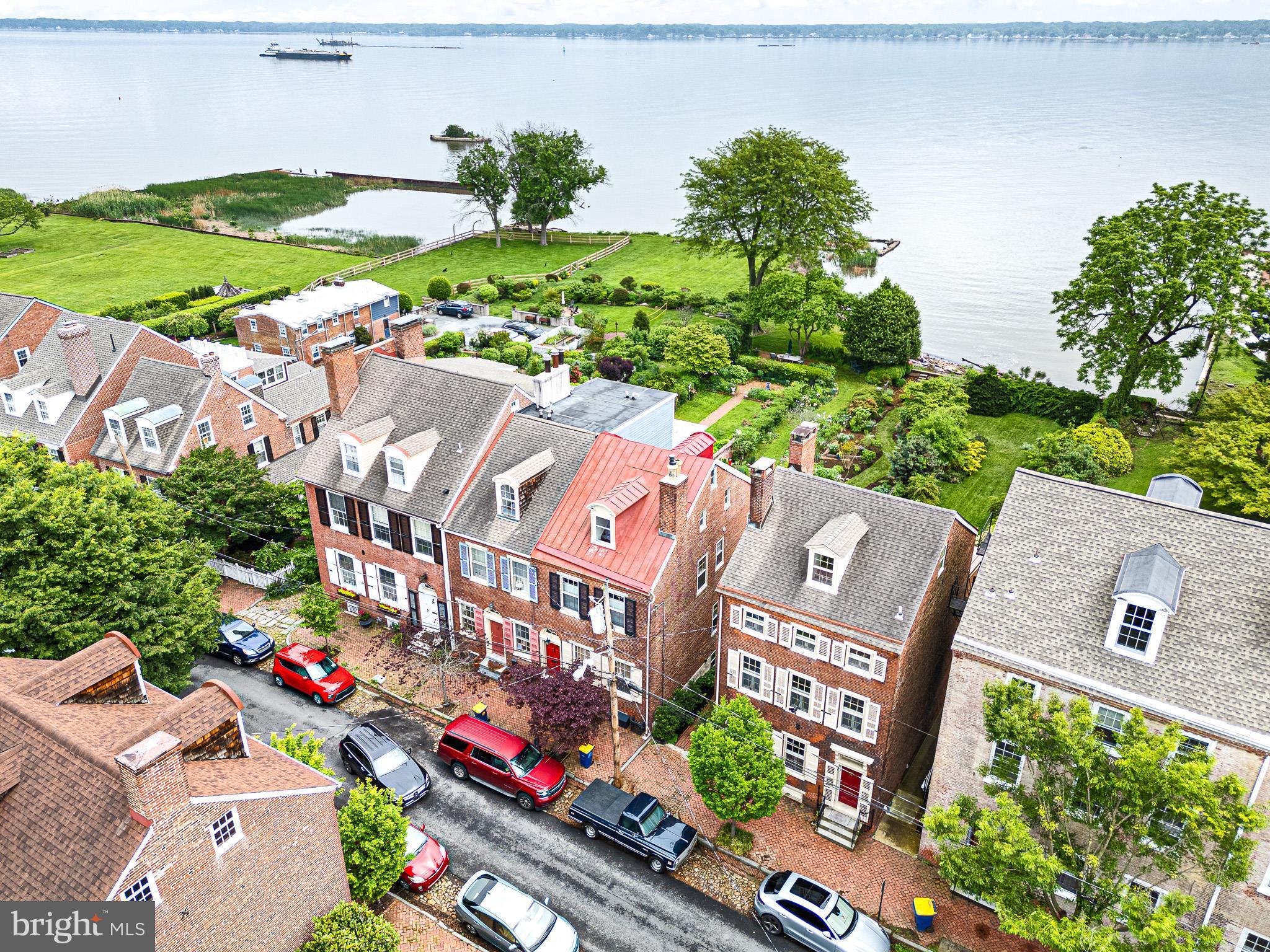 Experience timeless elegance & stunning river views from the comfort of your own home ***13 The Strand—an extraordinary historic home nestled along one of Historic New Castle’s most iconic and scenic streets! This beautifully updated residence offers the perfect blend of 19th-century charm with thoughtful modern upgrades *** including a new High Efficiency Gas Combi Boiler & Tankless Water heater. High ceilings, original wide plank floors, & historical architectural details are found throughout. Enter an elegant front foyer to a spacious living room which flows seamlessly into the formal dining room. Next is the Gourmet Chef’s Kitchen (a true showstopper) with granite countertops, a spacious island, maple & cherry cabinets. Its sitting area has a PANORAMIC wall of windows with stunning views of the garden & the Delaware River. The 2nd-floor Primary Suite features high ceilings, ample built-in storage, and a decorative fireplace. The spa-like bathroom is complete with ceramic tile walk-in shower, soaking tub, a custom-built vanity with granite counter tops, and plenty of storage. Also on the 2nd level is a library/office with a full wall of river-facing windows. The 3rd floor offers two additional bedrooms, a shared full bath, and cedar closet. The garden level en-suite features built-in wood shelving and a full bath with a step-in shower. The en-suite extends to the adjacent room which features original deep-silled windows and shutters set into a stone wall, and antique brick flooring. Off the brick patio a winding path leads you through three garden “rooms” with shrubs and perennials, many native to the Mid-Atlantic region. At river’s edge mature plantings surround a bluestone dining patio, providing a private space to enjoy river views. Walk down The Strand for easy access to New Castle’s historic museums, William Penn’s historical plaque and statue, the First State National Historical Park’s Welcome Center, and many restaurants and shops. Delaware’s Tall Ship the Kalmar Nyckel docks at the nearby wharf in season, and the Battery Park Trail wends from there south along the river. Community-organized events such as May Market, A Day in Old New Castle, Separation Day, and Spirit of Christmas provide numerous ways to explore and participate in celebrating the town. This is a truly unique opportunity to own a piece of Delaware’s history—with views, space, and a setting that’s simply unmatched.