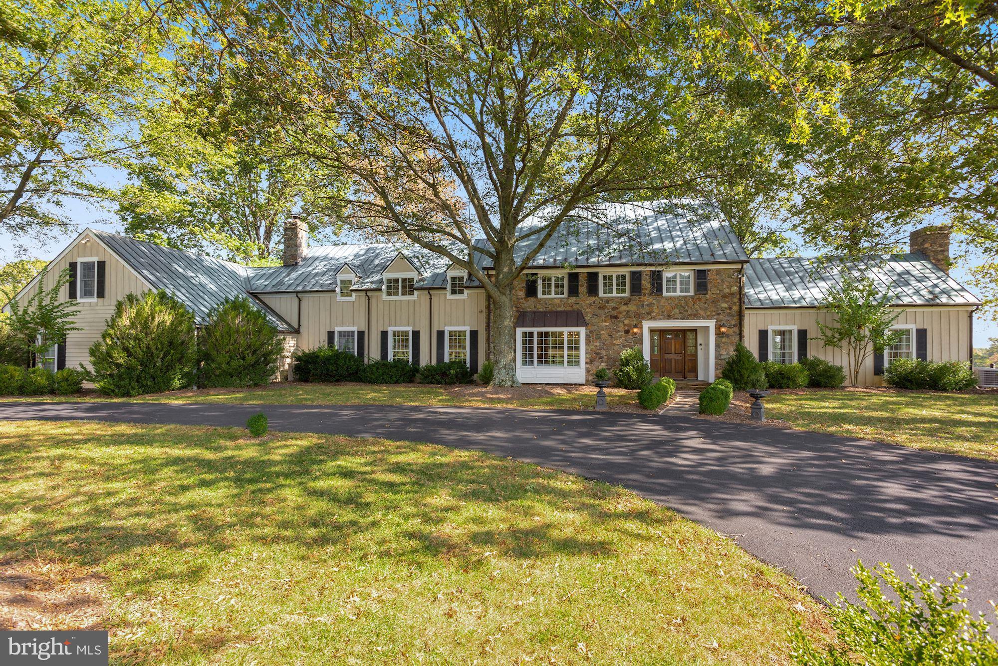 Absolutely stunning manor home with 4 bedrooms, 3 full bathrooms, and 3 half bathrooms with a beautiful lake view on 166 lush acres. This light-filled home features exposed beams, exquisite hardwood floors, updated bathrooms, custom cabinetry, and countertops. The large granite island in the kitchen, numerous living spaces, and back porch make this home an entertainer's delight. The main level office with beautiful built-ins and a large window make working from home a treat! The two-car attached garage features an upper-level apartment with 1 bedroom, 1 bathroom, kitchen, and living space. The property has a 3 bedroom, 2 bath guest cottage with 2 car garage, 9 stall barn with an indoor arena, a machine shed, and multiple paddocks with run-ins. Enjoy the Blue Ridge Mountains to the west and a peaceful lake to the east. Masks and gloves required when viewing the home.