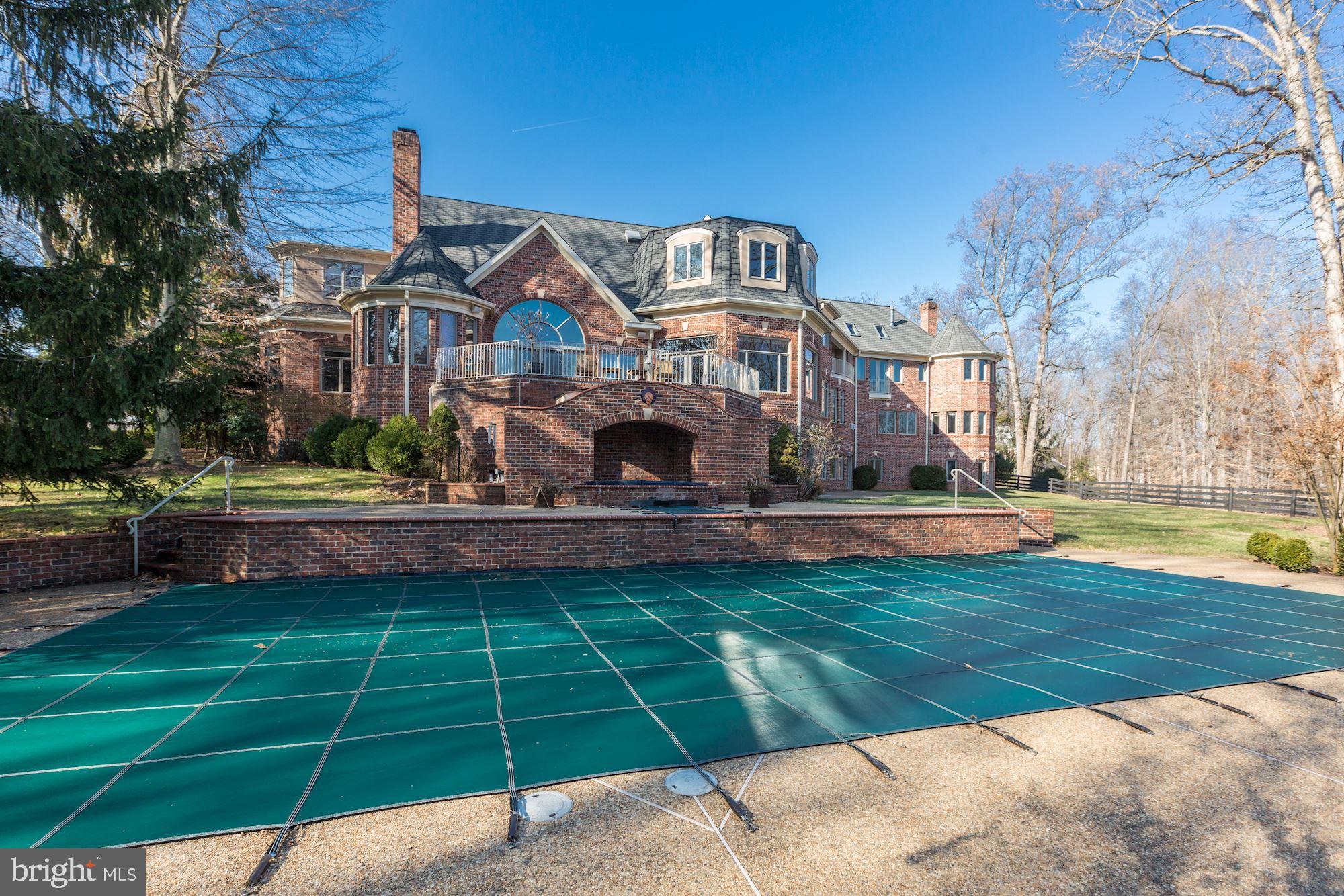 Exquisite gated estate on almost 5 acres with landscaped grounds that feature circular driveway,  pool & spa, tennis court, 5 stall barn with upper level office space and fenced paddock, screened in gazebo and 4 car garage with guest apartment on the upper level. This 13,000 square feet estate offers elegance in every room. An impressive 2- story marble foyer with a grand staircase welcomes you to the Reception, formal Living Room and Dining Room. The Library has built-in bookcases, wet bar and fireplace. The gourmet Kitchen in adorned with custom cabinetry, top-of-the-line appliances, wood-clad ceiling, huge walk-in Pantry and large windows that provide lots natural light. Continuing on the Main Level is the 2-story Great Room with built-ins, cathedral ceilings and stone fireplace, Main Level Bedroom with private bath and a In-Law Apartment complete with Kitchenette, Living Room, Bedroom and Full Bath. In the Upper Level is the Master Suite with a fireplace, luxurious Bath with separate vanities, dual walk-in Master Closets, Sauna and a 4th Level Sitting Room with skylights. In addition there are two Ensuites, Laundry Room and Lounge with built in cabinets. The Walk-out Lower Level is a true entertainers dream with a Recreation Room with fireplace, Media Room, Wet Bar,  custom Wine Cellar, Bedroom Suite with Sitting Room and private entrance. This property has two entrances, the second entrance is 639 River Bend Road, Great Falls.
