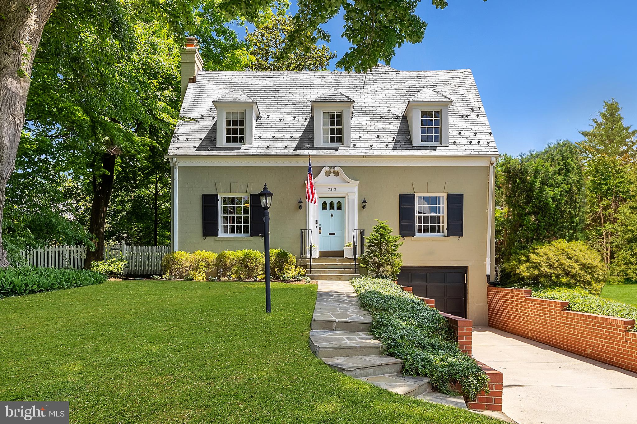 Set back from the verdant street in the heart of idyllic Martin’s Additions in Chevy Chase is this charming colonial. Originally constructed in 1935, the home retains its historic character while being fully upgraded to meet contemporary lifestyle preferences. A flagstone walkway leads to the inviting front entrance, where the home’s classic symmetry and dormers embedded in the slate roof offer effortless curb appeal. The traditional center hall floor plan features formal living and dining rooms flanking the entry foyer. Both spaces are generously proportioned, with the living room showcasing a roaring fireplace and the dining room providing an ideal setting for dinner parties.  Accessed via double doors off the living room is a private study complete with new custom built-ins and views out to the garden. In contrast to the formal areas, the informal spaces are open concept, suited to a modern style of living. The chef’s kitchen is the heart of the home, featuring modern cabinetry, stone countertops, stainless steel appliances, a commercial range,a stylish hood vent,and spacious pantry. A new backsplash and lighting enhance the space, which opens to the spacious family room. Here, a cozy wood-burning fireplace, refinished built-ins that offer ample storage, a large bay window, and direct patio access create the perfect gathering place. An elegant, newly renovated full bath completes the main level. Upstairs, the luxurious primary suite features an inviting integrated bench beneath the bay window, private roaring fireplace, and new closets. Its sumptuous ensuite bath boasts a double vanity, soaking tub, and separate walk-in glass shower. Two additional bedrooms and a hall bath complete the upper level offering ample accommodation. The freshly updated lower level offers a recreation space for true multipurpose flexibility. The newly updated powder room and direct access to the attached garage complete the space. A true highlight of the home is the parcel of land it is situated on, for both its outdoor space and prestigious location. Adjacent to the flagstone patio off the family room is a large, flat, usable grassy backyard. Fully fenced and shaded by lush, mature foliage, the rear lawn offers complete privacy and is effortlessly maintained by the all encompassing irrigation system. The unparalleled location is steps away from Chevy Chase Park, the weekly farmer's market, Olympia Cafe, Brookville Supermarket, and the legendary La Ferme Restaurant, as well as falling within the CCRA Swim and Tennis Club scope. Perfectly blending historic charm and modern livability and situated in one of the Capital Region’s most sought-after communities, 7213 Chestnut Street represents the epitome of Chevy Chase living.