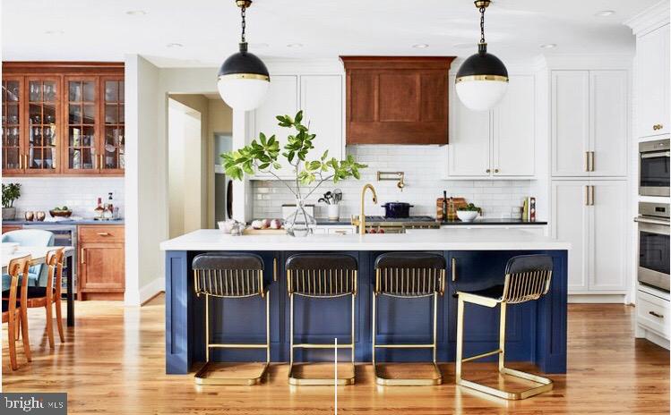 This quintessential Morris-Day has been meticulously enhanced, including new 2019 kitchen, master bath and screen porch renovations; the 2019 bespoke kitchen was recently featured on the cover of Home & Design. Sophisticated finishes throughout include custom wall and window treatments that are complimented by designer lighting and tile. The three superbly finished and intelligently laid-out levels provide a floor plan that is open concept for entertaining yet practical for everyday living. The exterior has been planned with the utmost discernment, executed to provide a private backyard retreat which features a stone patio, a lovely 2019 screen porch with new Ipe decking and a heated pool. The rear yard is fully fenced and is surrounded by beautiful flowering, mature plantings and strategically chosen and placed trees. A quaint side garden offers a built-in grill and a patio off the kitchen which adds to the experience. The open-concept kitchen with its custom, oversized cabinetry and crisp-white tile backsplash offsets a cherry-stained wood hood and navy-blue island with Visual Comfort lighting in both kitchen and breakfast area. Silestone Countertops, Mullions and millwork surrounding the windows, brass accents and hardware unify the space, and windows bring the outdoors in.The smart layout begins with both a generously sized family entrance with mudroom and a formal, two-story entry foyer, which flows into the formal living and dining rooms, as well as the library. The comfortable family living area with fireplace, mahogany patio access and screened porch offers views of the yard and heated pool. The upper level houses a master suite that offers a sitting room, two walk-in closets, second laundry, and stunning new bathroom. The aesthetic of every hall, foyer and has been meticulously curated, with no detail overlooked. The lower level complements the amenities and just as every level has been improved or upgraded, this one conveys a quintessentially modern recreation media room with modern wet bar and ample storage, a guest bedroom with ensuite bath, and laundry room with storage.