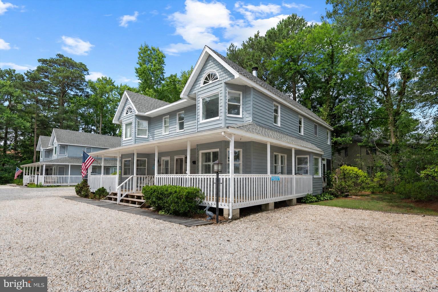 Less than four blocks from the sand and surf, this beautiful end-unit townhome is ideally situated for enjoying the best of Bethany Beach. A welcoming wrap-around front porch sets the tone for this charming retreat. Inside, the open-concept main level showcases ceramic tile flooring and plantation shutters throughout, creating a bright, coastal feel. The spacious living area with a cozy wood-burning fireplace flows seamlessly into the dining area and kitchen. The kitchen offers granite countertops, crisp white cabinetry, and a breakfast bar pass-through, while an enclosed porch just off the kitchen provides additional living space. The main level also includes a laundry room and an updated half bath. Upstairs, the primary bedroom features an updated ensuite bathroom with a beautifully tiled walk-in shower, accompanied by two spacious guest bedrooms and another updated full bath. Luxury vinyl plank flooring extends throughout the second floor. Additional highlights include an outdoor shower, an encapsulated crawl space, and a freshly painted interior. Offered fully furnished, this home is ready for immediate enjoyment or presents an exceptional investment opportunity. Tucked away in the community of Garfield Station, a private enclave of just eight homes, this property offers a peaceful setting just a short stroll from Bethany Beach, outstanding restaurants, boutique shopping, and everything downtown Bethany has to offer.